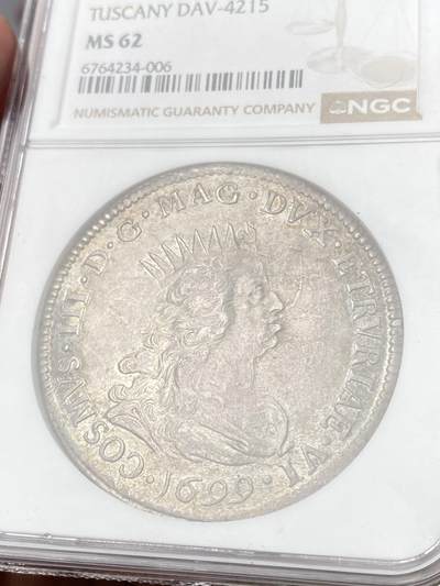 万国钱币拍卖第061期（马年首拍） NGC MS62 1699年意大利托斯卡纳大公科西莫三世·德·美第奇海景塔勒大银 作为佛罗伦萨最为出名的名门望族 文艺复兴的中流砥柱 美第奇家族已然成为了艺术史上绕不开的名字 其对发行钱币的艺术追求自然也是领先于时代 而此枚海景塔勒就是其中的代表之作 这枚发行于17世纪末的大银描绘了当时利沃诺港口的繁荣景象 打制清晰 光度柔和 优雅地中海淡彩包浆环绕 不容错过的典藏级品质