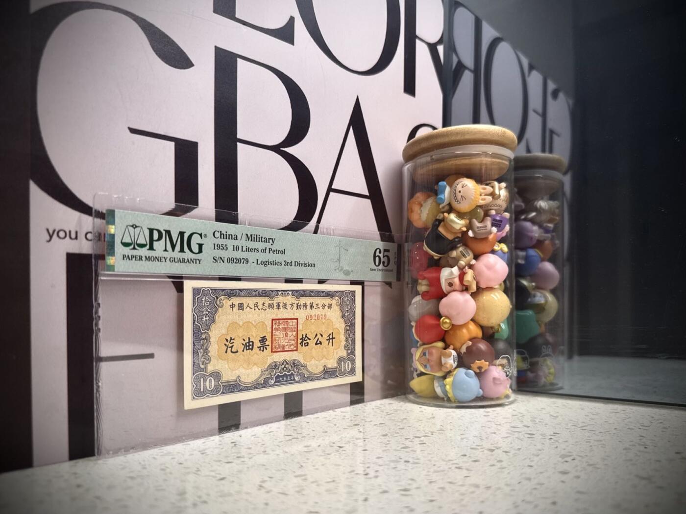 【乾奕收藏】1955年中国人民志愿军后方勤务第三分部汽油票拾公升，美国PMG65E，号码全程无34北斗号，这张汽油票发行于1955年，此时抗美援朝战争已经结束（1953年停战），但中国人民志愿军仍在朝鲜境内执行任务，需要统一的后勤保障体系。用于在志愿军内部兑换汽油，是当时军队后勤管理的重要凭证，反映了志愿军在朝鲜的物资调配体系