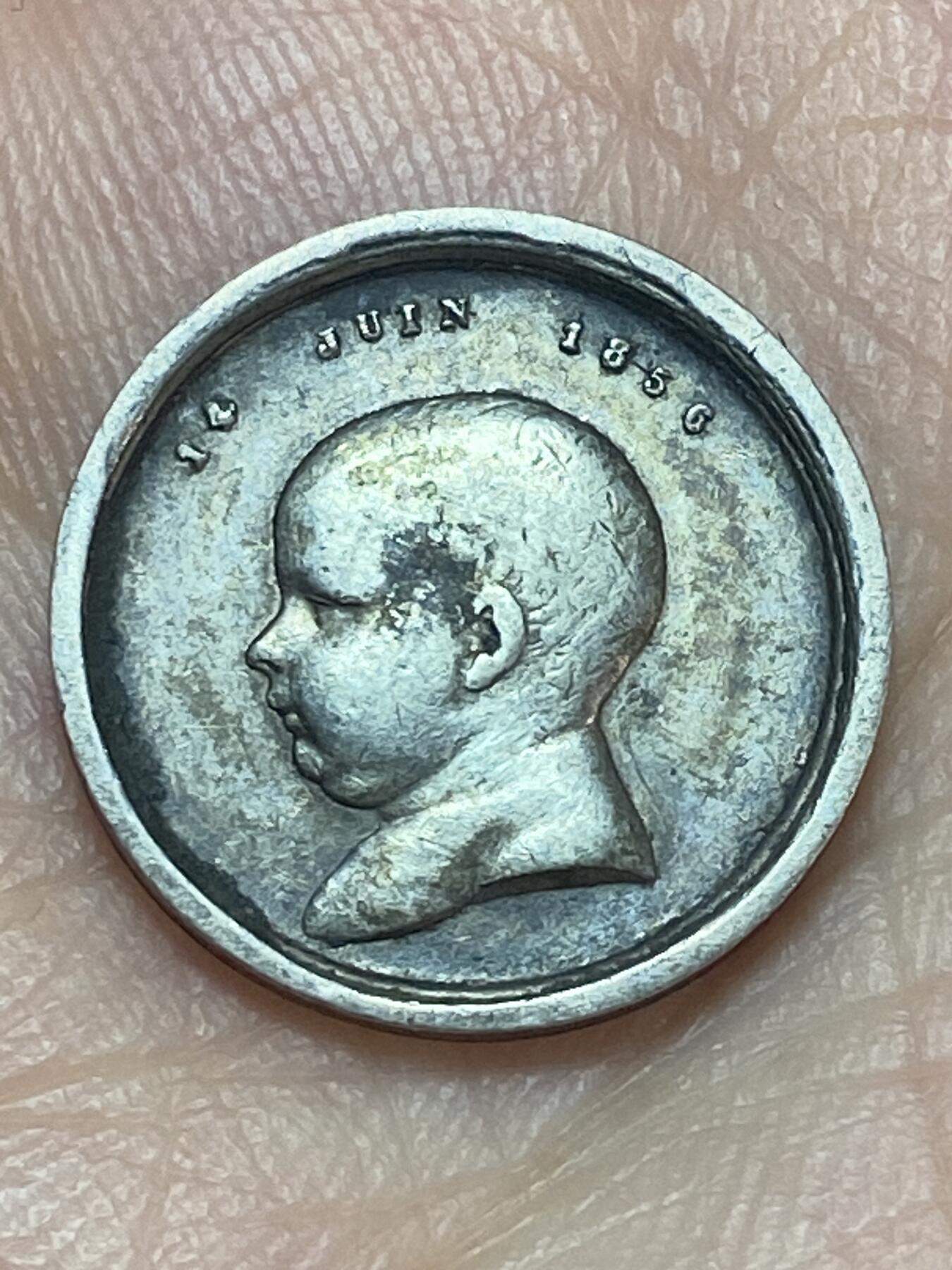 2026年第二十八场(总第一百九十七场）新春初七特拍场(佣金3%最低1元) 法国1856年拿破仑四世诞生受洗小银章(直径15mm，重1.98克，950高银，拿破仑四世1856.3.16出生，是拿破仑三世和欧仁妮皇后独子，1870普法战争色当惨败，随父母流亡英国。入读英国伍尔维奇皇家军事学院后成绩优异获中尉军衔，1879年主动加入英军赴南非参加祖鲁战争。率侦察小队深入祖鲁兰，遭伏击，身中祖鲁人17矛战死。终年23岁。他的死彻底终结波拿巴王朝复辟希望，法国第三共和国彻底巩固)