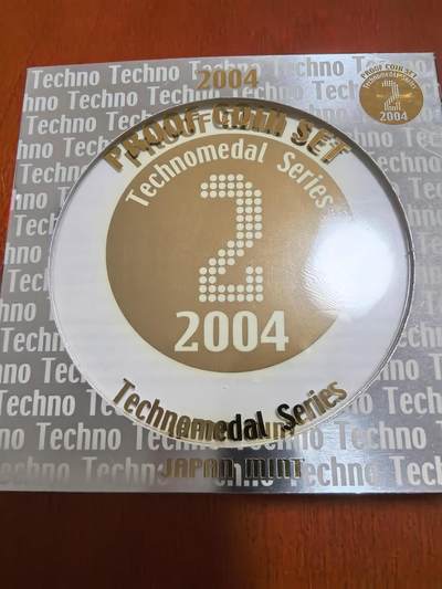 长老汇马年精选第一场拍卖 - 2004日本科技系列之二6枚精制币套装小方盒，含银质梅花形镀金银章1枚