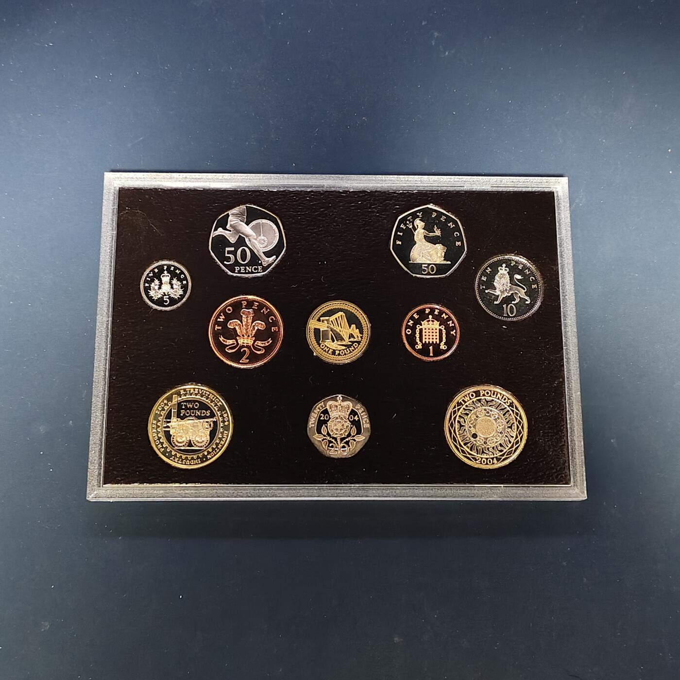 【全场包邮】纯粹捡漏拍505场 英国2004年官方红本精制套币-盒证全带详细介绍手册-含2镑首辆火车+1镑第四铁路桥+50便士罗杰班尼斯精制纪念币