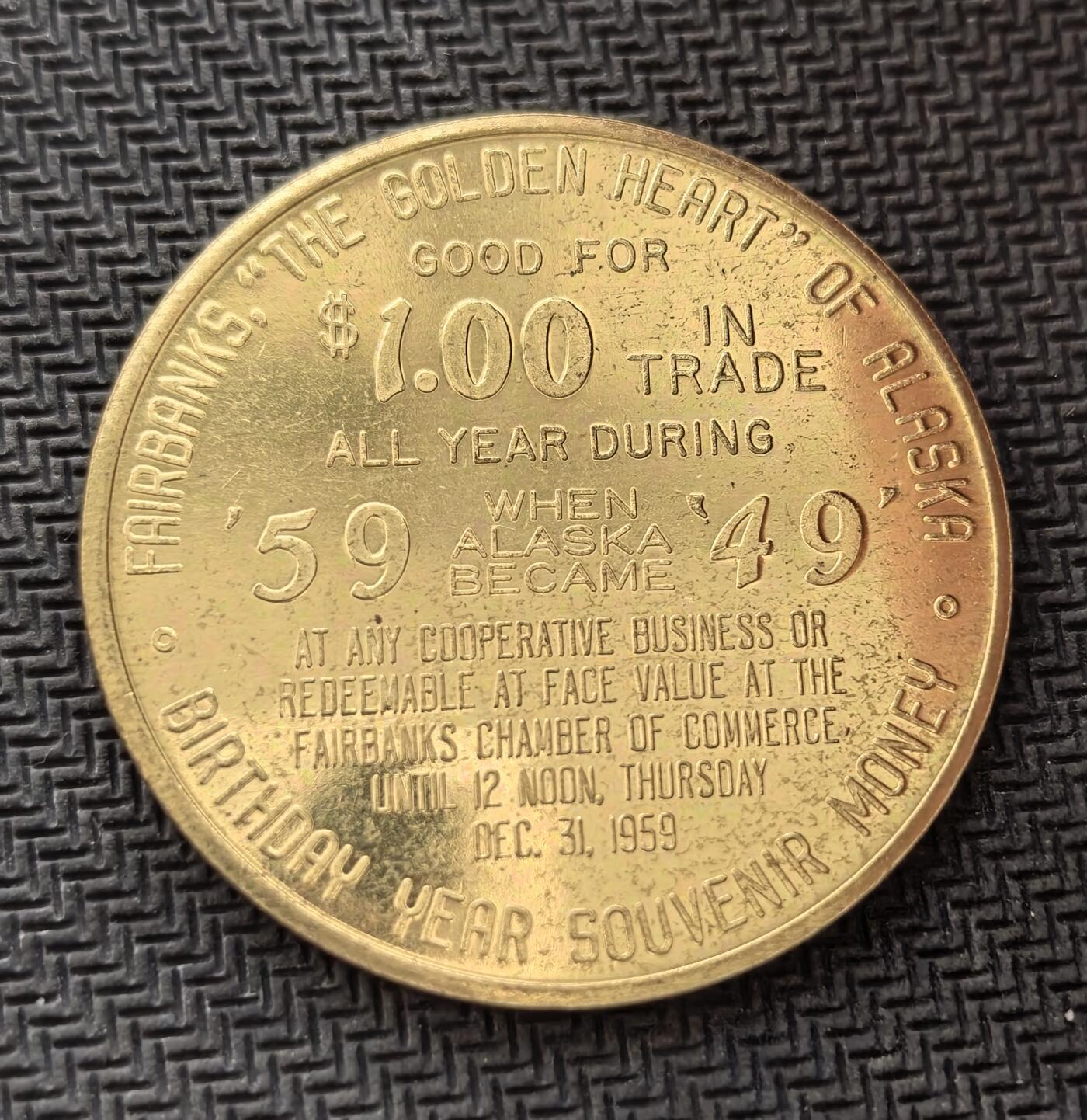 外国优质老铜币银币，周日九点倒数截拍，满百包邮，持续收拍，初八发货 美国1959年阿拉斯加州加入美国联邦1美元代用币。正面图案展现了极光、山脉、港口与狗拉雪橇等阿拉斯加标志性元素；背面标注 “可在费尔班克斯市按 1 美元流通”，它既是州庆纪念品，也是当年当地的临时代用币，见证了阿拉斯加加入联邦的历史时刻。
