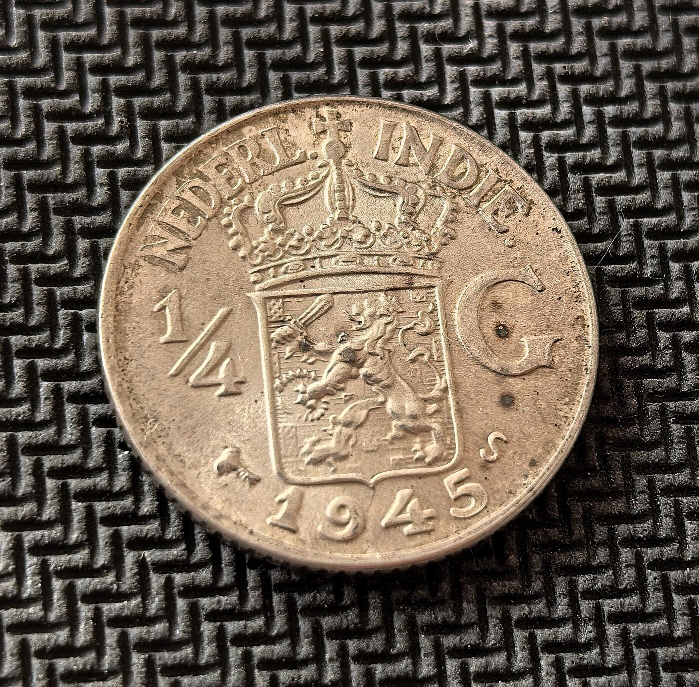 外国优质老铜币银币，周日九点倒数截拍，满百包邮，持续收拍，初八发货 荷属东印度1945年1/4 盾银币，发行于二战日本占领结束后、印尼独立前夕。正面的荷兰国徽彰显殖民余威，背面的爪夷文则体现本土文化印记，是殖民体系瓦解与民族独立浪潮交织的历史见证。