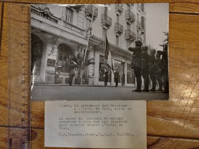 凯旋世界勋赏（持续上新中）（第22期新年大拍）（欢迎送拍）（对拍品有疑问请询问客服，不接受到手刀，出价默认拍品品相。请认真阅读拍卖规则！出价默认已认可！）（收到货请录制开箱视频，无视频概不处理问题。） - 维希。升旗仪式  在政府所在地——公园酒店（Hôtel du Parc）。  元帅卫队在公园酒店前举行升旗仪式并致敬。  P.R.Trampus 摄于维希，1941年9月18日，编号V.16266。背面特兰普斯新闻摄影社 版权所有维希法国重要人物 皮埃尔·赖伐尔（Pierre Laval） 的签名。他是维希政府的核心人物，曾担任总理，是与纳粹德国合作的主要代表。（详细看介绍）