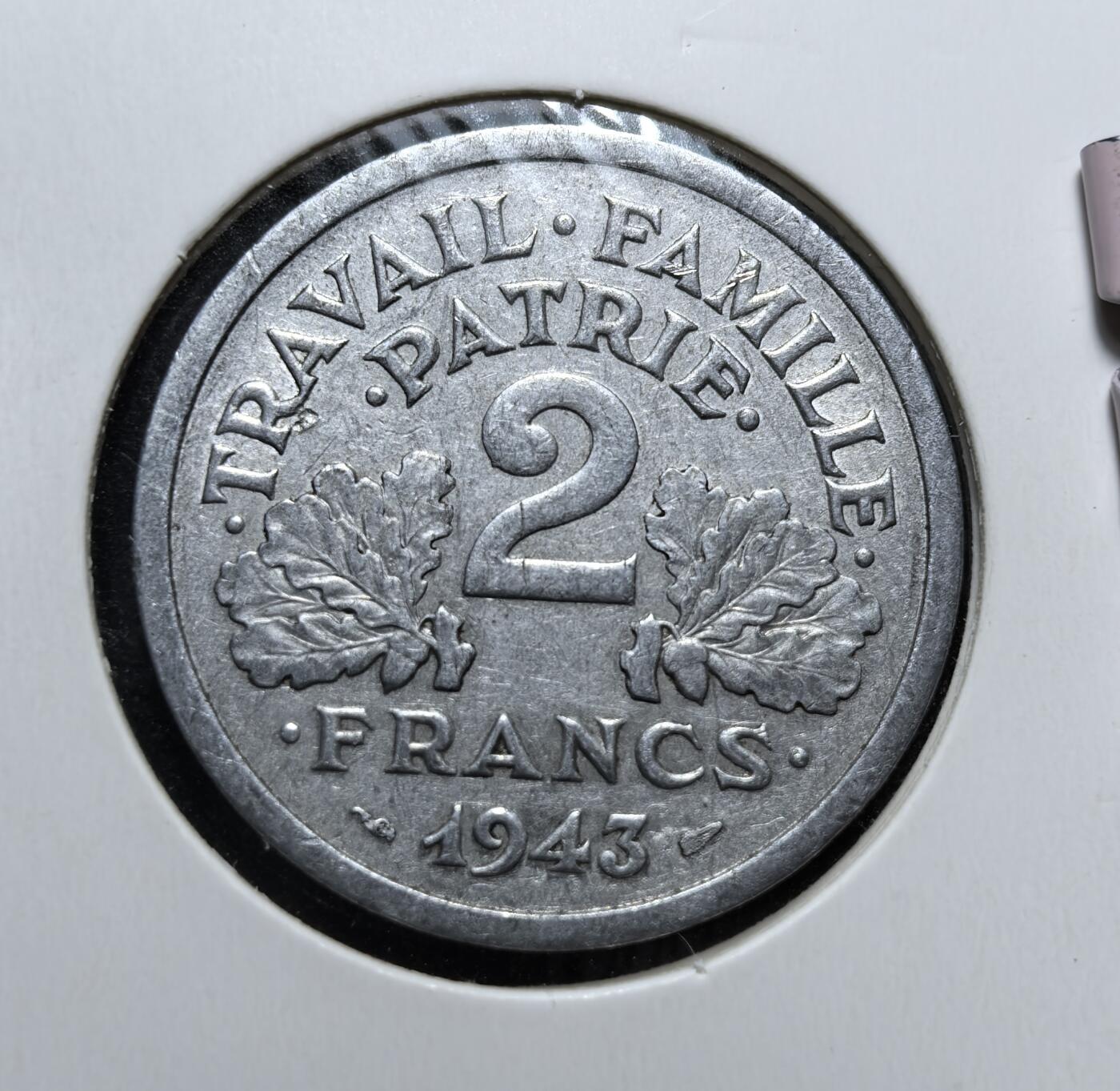 外国优质老铜币银币，周日九点倒数截拍，满百包邮，持续收拍，初八发货 维希法国1943 年2 法郎铝币，是二战时期法国傀儡政权的流通货币。正面的束棒与麦穗象征极权与农业，背面的 “劳动、家庭、祖国” 是维希政权的核心口号，见证了法国被占领时期的屈辱历史。