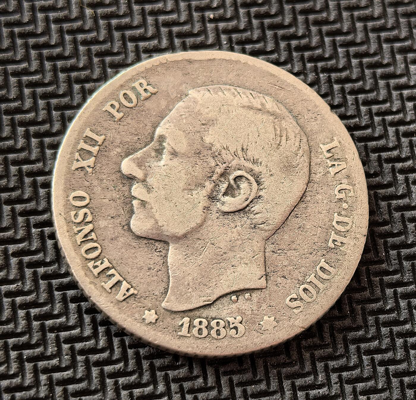 外国优质老铜币银币，周日九点倒数截拍，满百包邮，持续收拍，初八发货 西班牙1885 年1比塞塔银币，发行于阿方索十二世统治时期。正面为国王头像，彰显君主权威；背面的西班牙国徽与 “UNA PESETA” 字样，见证了西班牙帝国在殖民体系瓦解前的最后余晖，是近代西班牙历史的重要物证。