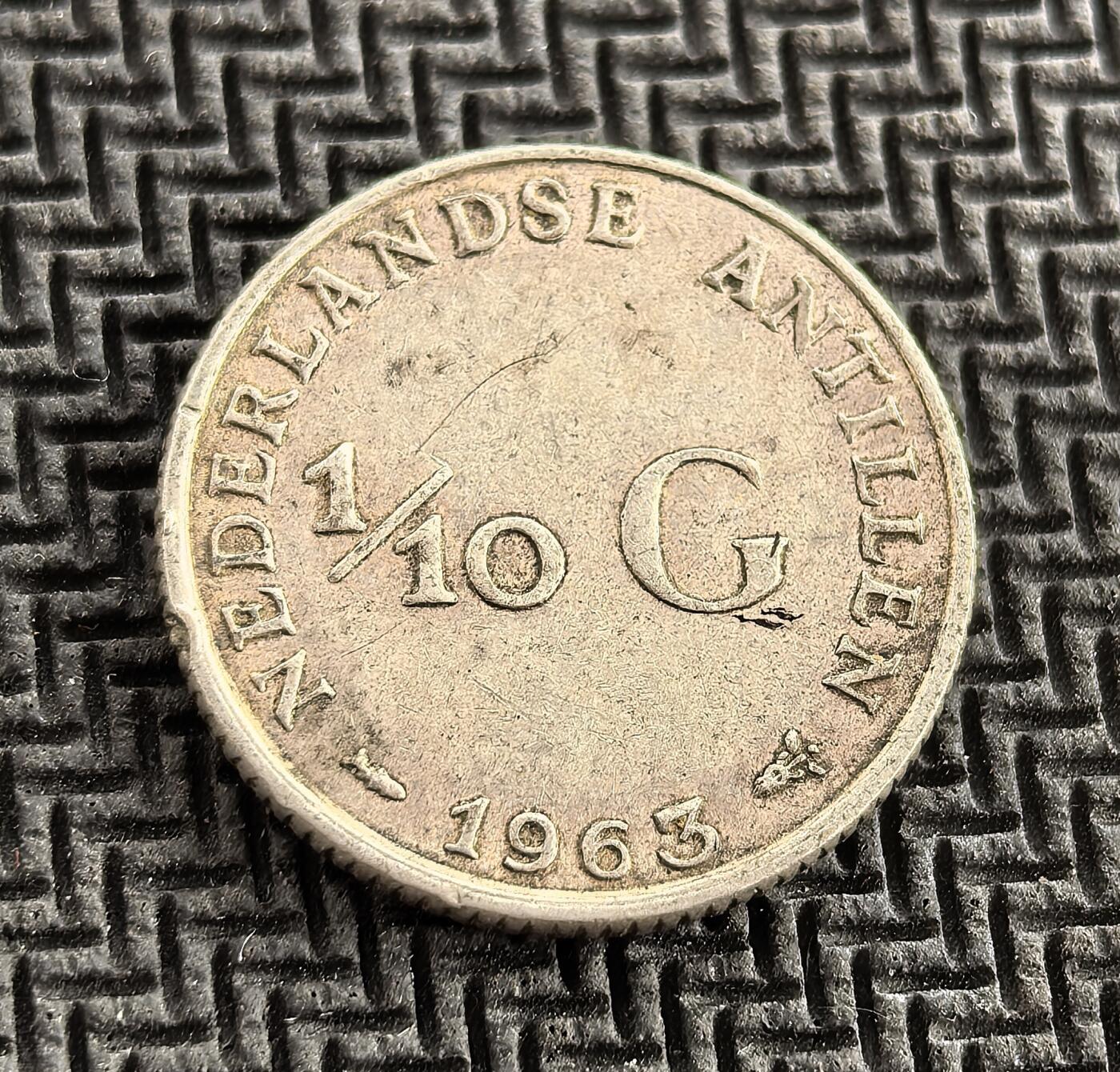 外国优质老铜币银币，周日九点倒数截拍，满百包邮，持续收拍，初八发货 荷属安的列斯1963 年 1/10 盾银币，正面为荷兰朱丽安娜女王像，彰显宗主国权威；背面标注 “NEDERLANDSE ANTILLEN”，见证荷属加勒比殖民地的货币体系，是殖民时代与战后荷兰王国海外领地治理的历史缩影。