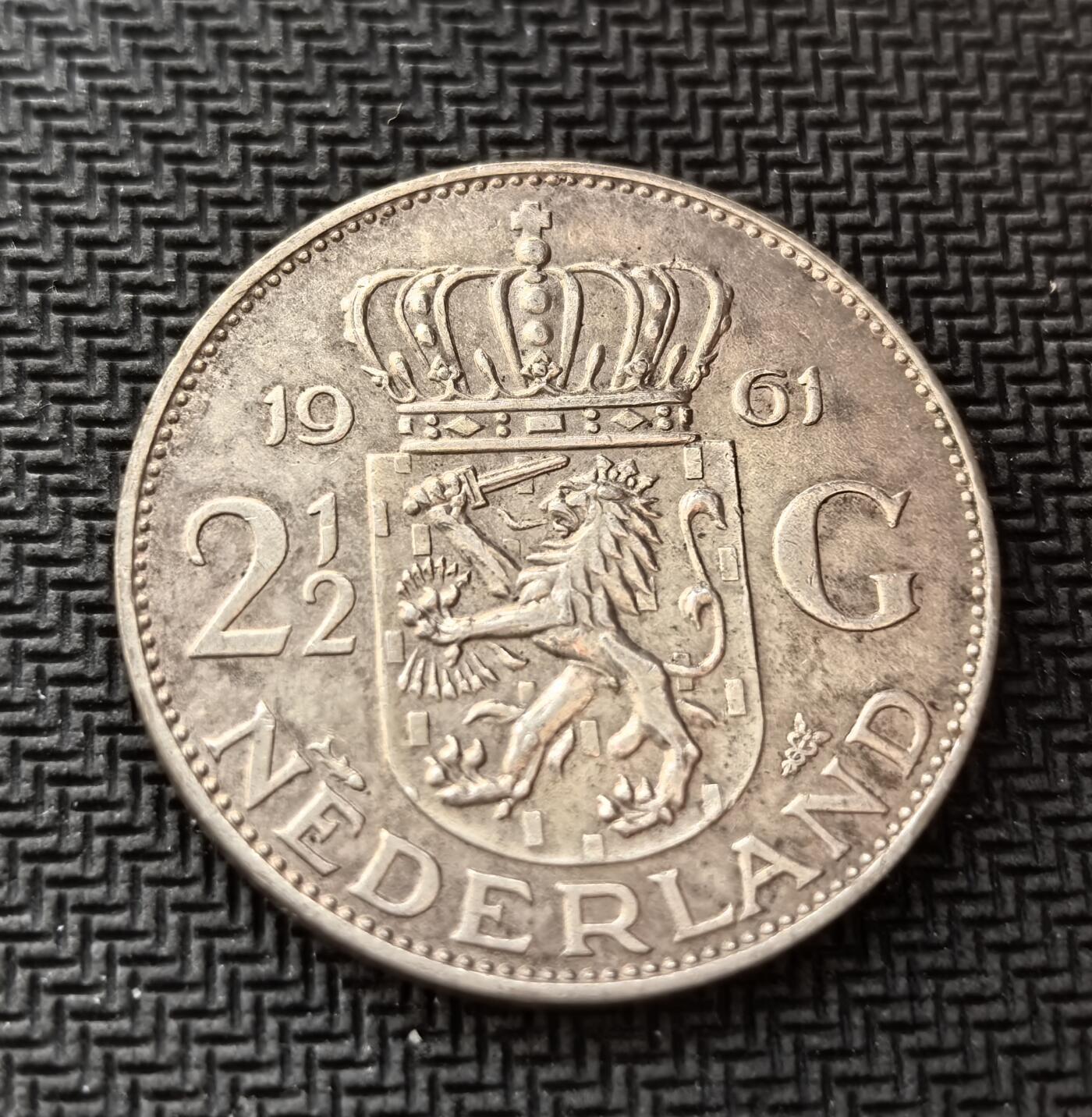 外国优质老铜币银币，周日九点倒数截拍，满百包邮，持续收拍，初八发货 荷兰1961年2½ 盾银币，发行于朱丽安娜女王统治时期。正面的荷兰国徽彰显国家主权，背面的女王头像象征君主立宪制下的稳定统治，见证了二战后荷兰经济复苏与殖民体系瓦解的转型阶段。