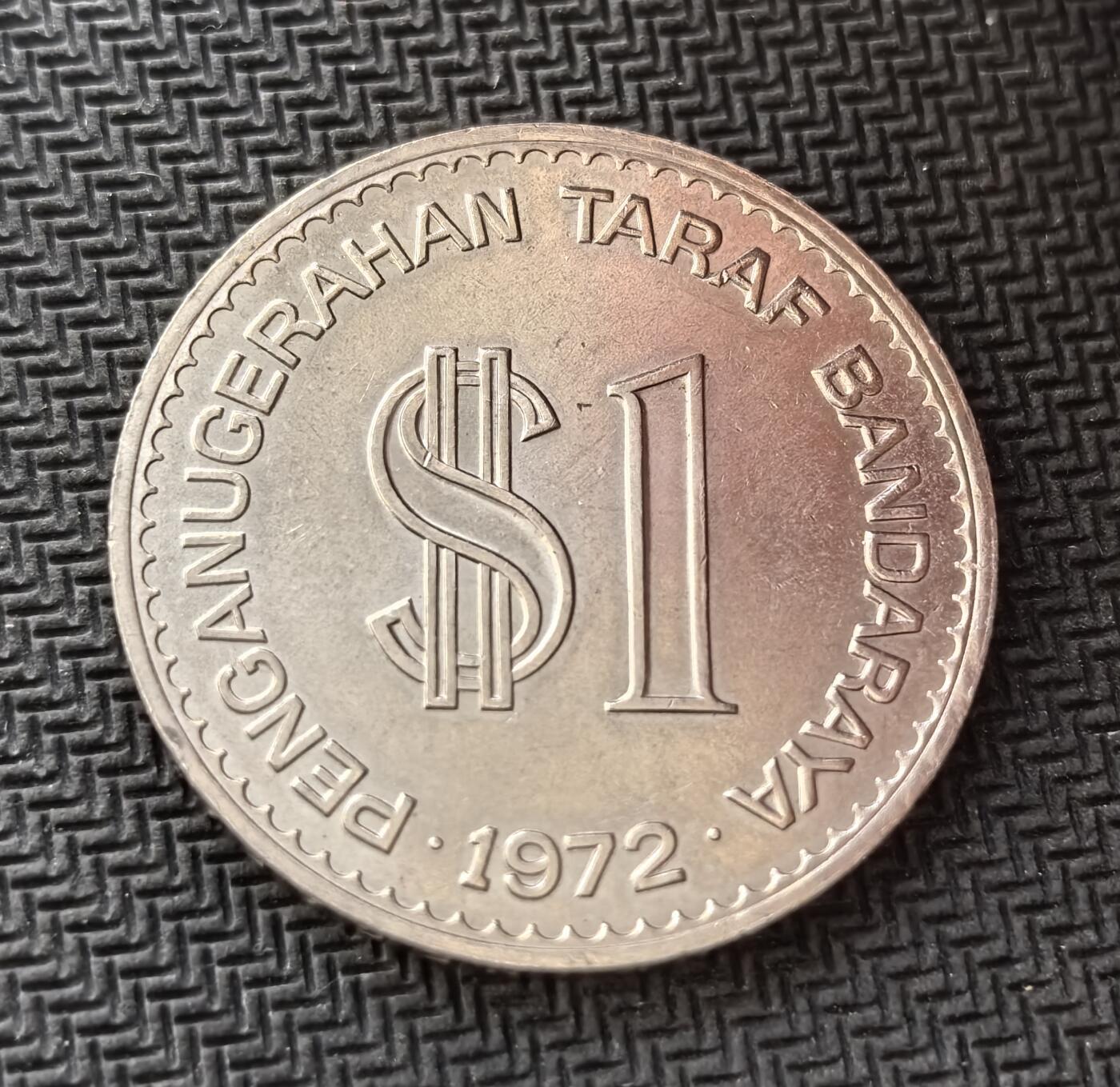 外国优质老铜币银币，周日九点倒数截拍，满百包邮，持续收拍，初八发货 马来西亚1972年吉隆坡建都1 林吉特纪念币。正面的 “PENGANUGERAHAN TARAF BANDARAYA” 字样，代表了这一重要的行政地位提升；背面的 “KUALA LUMPUR MAJU DAN MAKMUR”（吉隆坡繁荣进步）及象征科技、教育、贸易的图案，见证了吉隆坡作为国家首都的发展愿景。