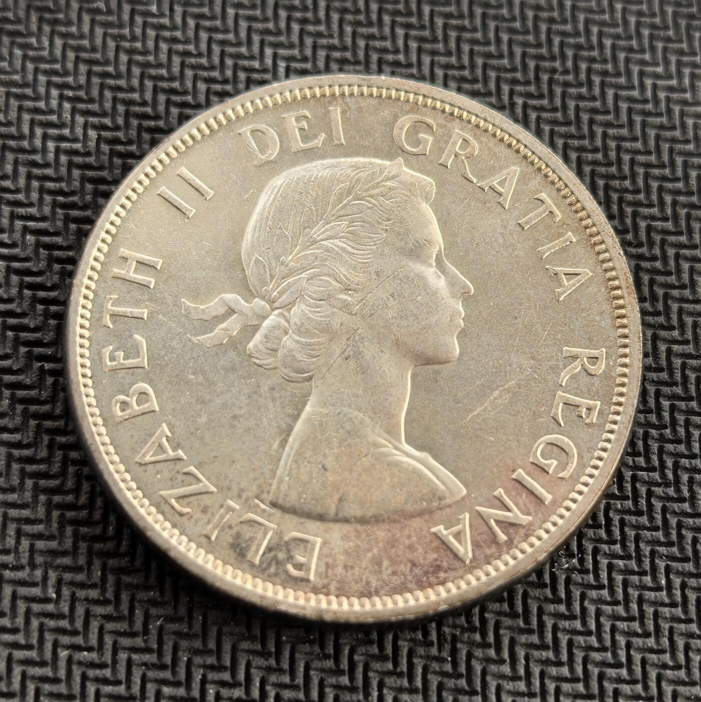 外国优质老铜币银币，周日九点倒数截拍，满百包邮，持续收拍，初八发货 加拿大1961 年一元银币，发行于二战后加拿大经济腾飞期，正面为伊丽莎白二世像，铭文彰显英联邦渊源；背面独木舟图案还原早期毛皮贸易场景，“HB” 暗指哈德逊湾公司，是加拿大殖民开拓史的重要见证。