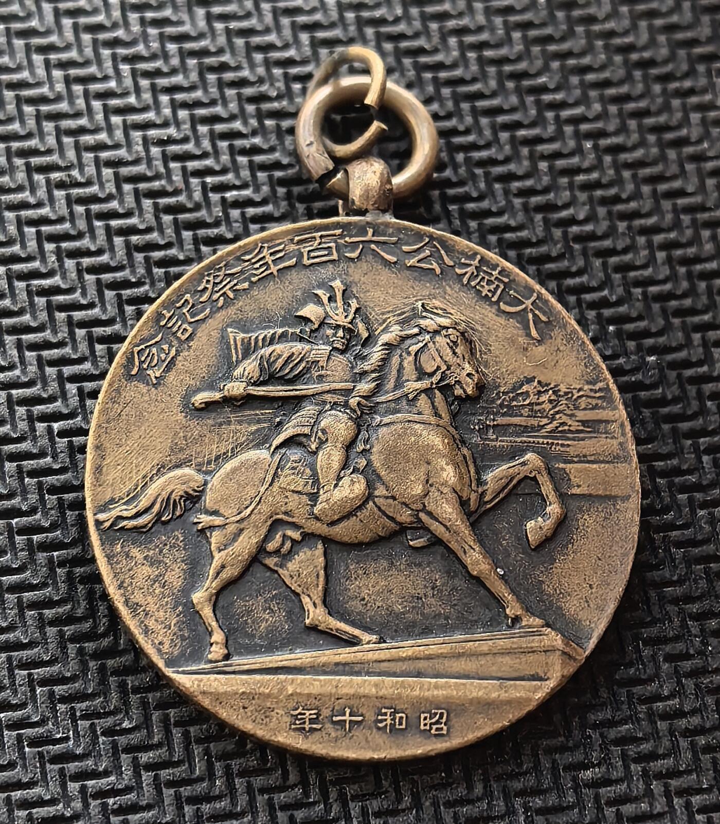 外国优质老铜币银币，周日九点倒数截拍，满百包邮，持续收拍，初八发货 昭和十年（1935 年）的铜质纪念章，是为纪念大楠公六百年祭而制。正面刻画了日本南北朝名将楠木正成骑马挥刀的形象，背面则是祭祀场景与山水纹饰。它诞生于日本军国主义抬头的年代，既承载着对 “忠臣” 的推崇，也反映了当时的社会思潮与历史叙事。