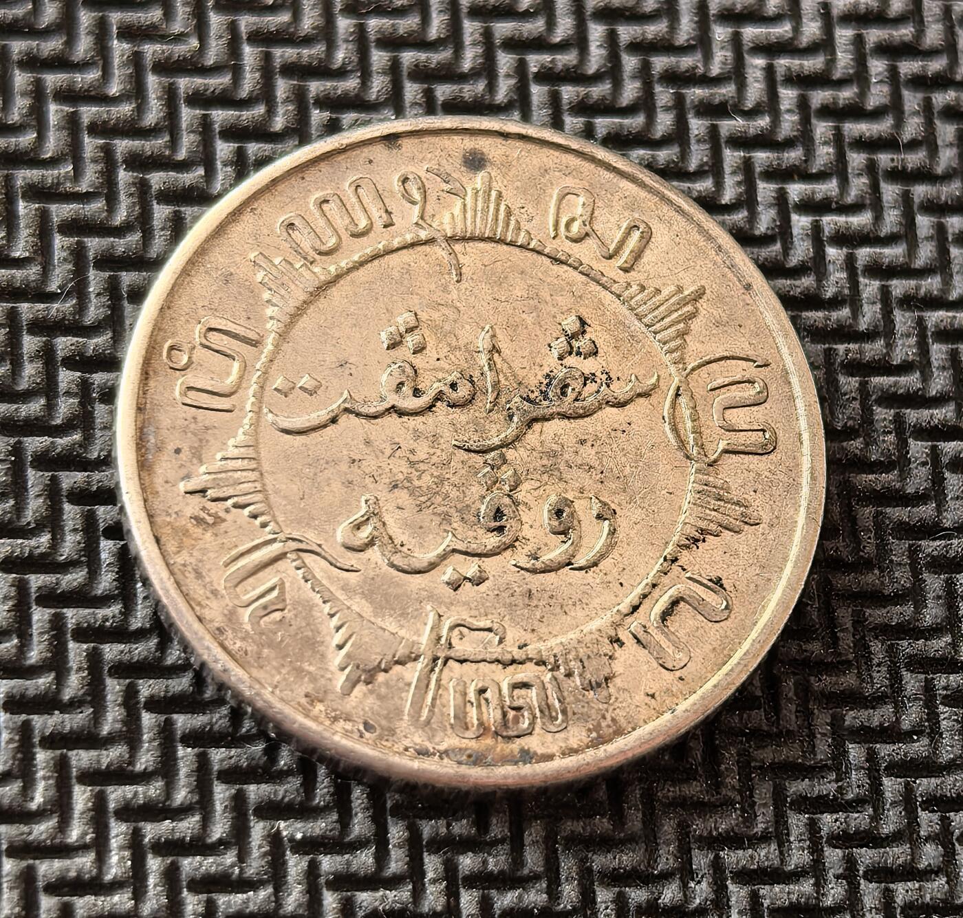 外国优质老铜币银币，周日九点倒数截拍，满百包邮，持续收拍，初八发货 荷属东印度1942年1/4 盾银币，发行于二战日本占领期间。正面的荷兰国徽是殖民统治的象征，背面的爪夷文则体现了本土文化印记，它见证了殖民体系在战争冲击下的瓦解，是东南亚近代殖民史的重要载体。