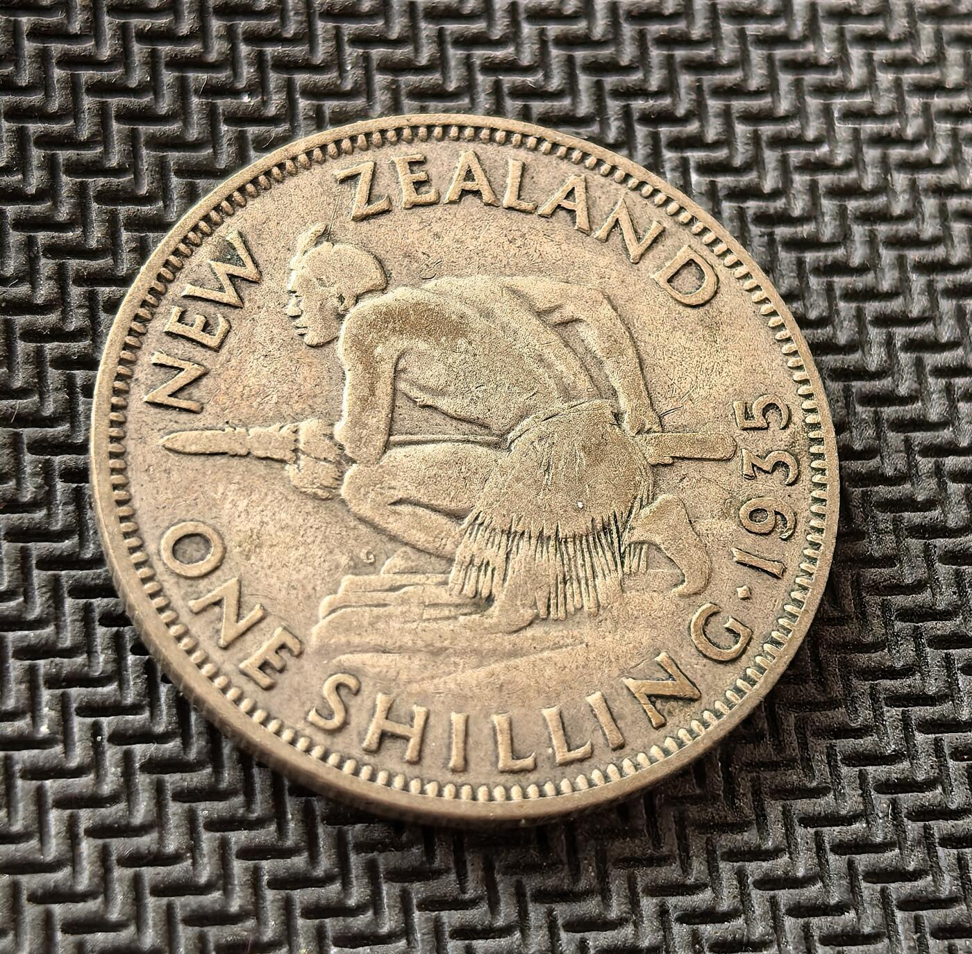 外国优质老铜币银币，周日九点倒数截拍，满百包邮，持续收拍，初八发货 新西兰1935年1 先令银币，发行于英联邦自治领时期。正面为英王乔治五世像，彰显宗主国权威；背面的毛利战士形象，既体现本土文化，也反映殖民时代对原住民符号的运用，是新西兰殖民史的缩影。