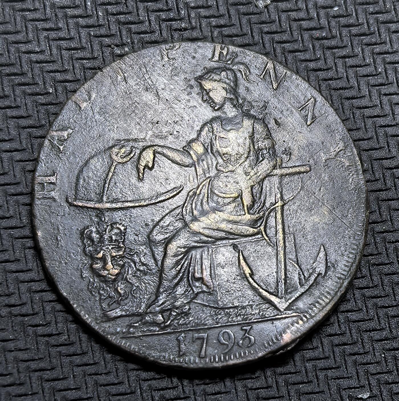 外国优质老铜币银币，周日九点倒数截拍，满百包邮，持续收拍，初八发货 图案清晰英国1793年半便士代用币。正面刻有和平与丰饶，衔着橄榄枝的鸽子与丰饶角图案，寄托了对和平与富足的期盼；背面的 “HALFPENNY” 与 1793 年字样，以及象征商业与海洋的坐像、锚和狮子，反映了工业革命初期英国的经济活力与殖民野心。这枚代用币是地方发行的私铸货币，用于缓解当时官方货币短缺的困境。虽然图案清晰但是币有不平边翘。