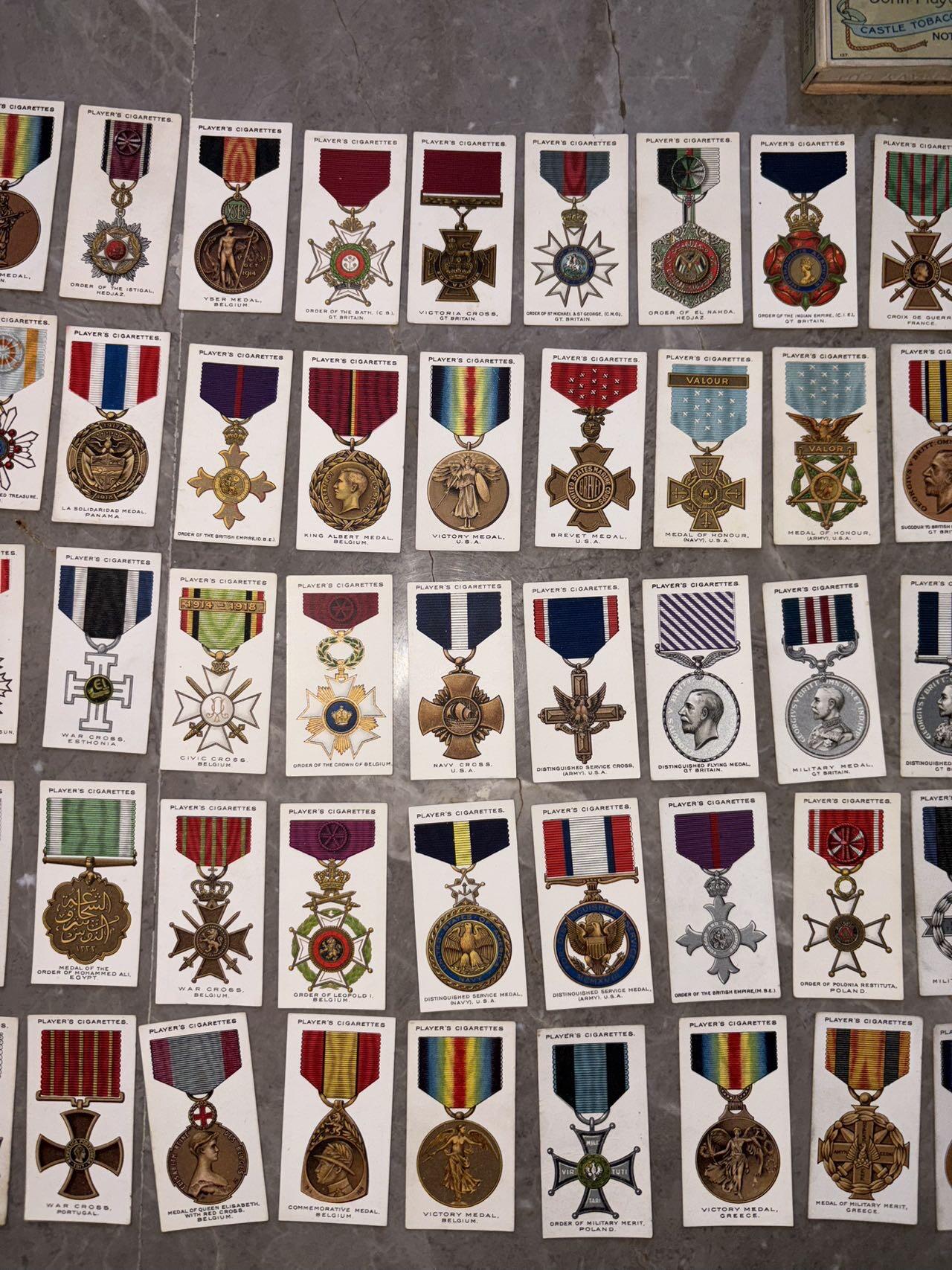 盛世勋华——号角文化勋章邮票专场拍卖第307期 英国1927年“战争勋章与奖章”系列烟卡（共90种 ）少见带原盒，收录了主要参战胜利国的相关勋奖章，并附有详细文字介绍。其中就包含著名的一战胜利彩虹系列奖章，以及英国，法国，美国，日本等国主要勋奖章。