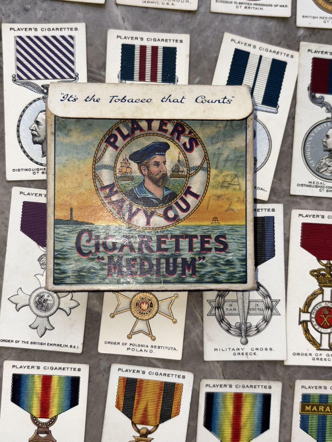 盛世勋华——号角文化勋章邮票专场拍卖第307期 英国1927年“战争勋章与奖章”系列烟卡（共90种 ）少见带原盒，收录了主要参战胜利国的相关勋奖章，并附有详细文字介绍。其中就包含著名的一战胜利彩虹系列奖章，以及英国，法国，美国，日本等国主要勋奖章。