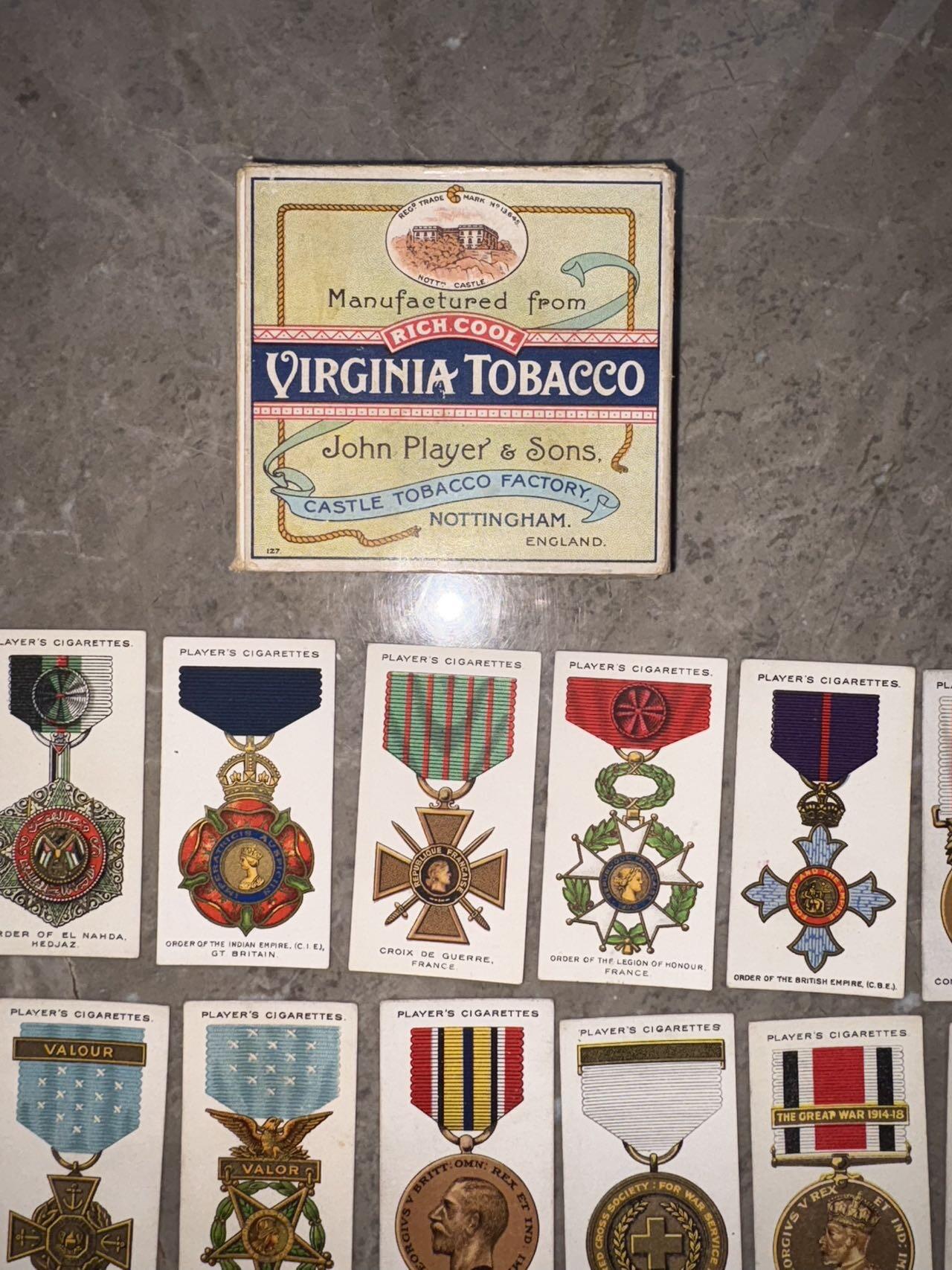 盛世勋华——号角文化勋章邮票专场拍卖第307期 英国1927年“战争勋章与奖章”系列烟卡（共90种 ）少见带原盒，收录了主要参战胜利国的相关勋奖章，并附有详细文字介绍。其中就包含著名的一战胜利彩虹系列奖章，以及英国，法国，美国，日本等国主要勋奖章。