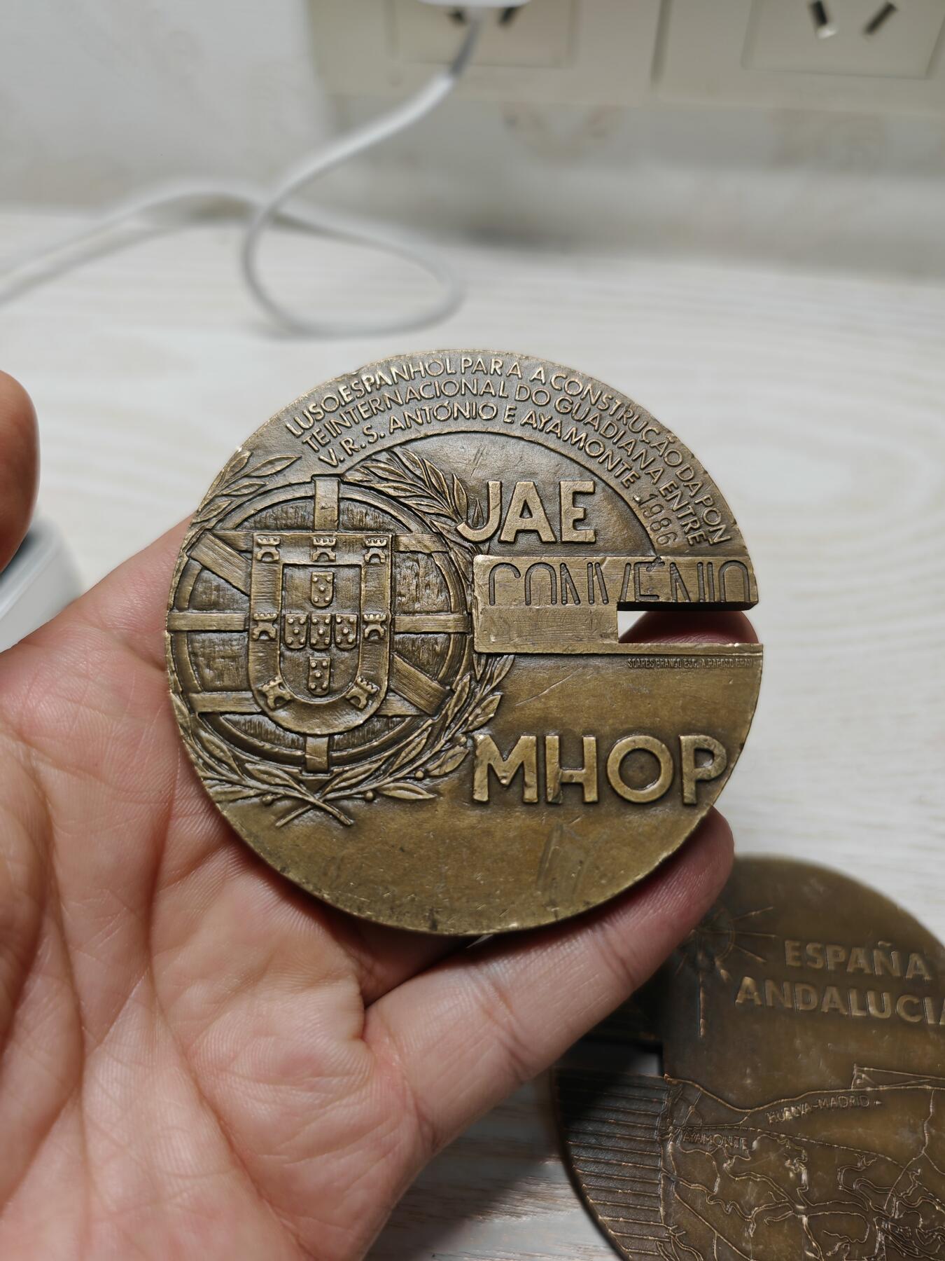 1986 年葡萄牙和西班牙合作建设瓜迪亚纳河国际大桥而制作，分别从葡西两国视角，结合各自的大区（阿尔加维、安达卢西亚 ）地理、国徽元素，记录和彰显这一跨境交通基础设施建设的重要事件，具有纪念葡西友好合作、区域交通发展的意义 ，很有设计感，可拆可合