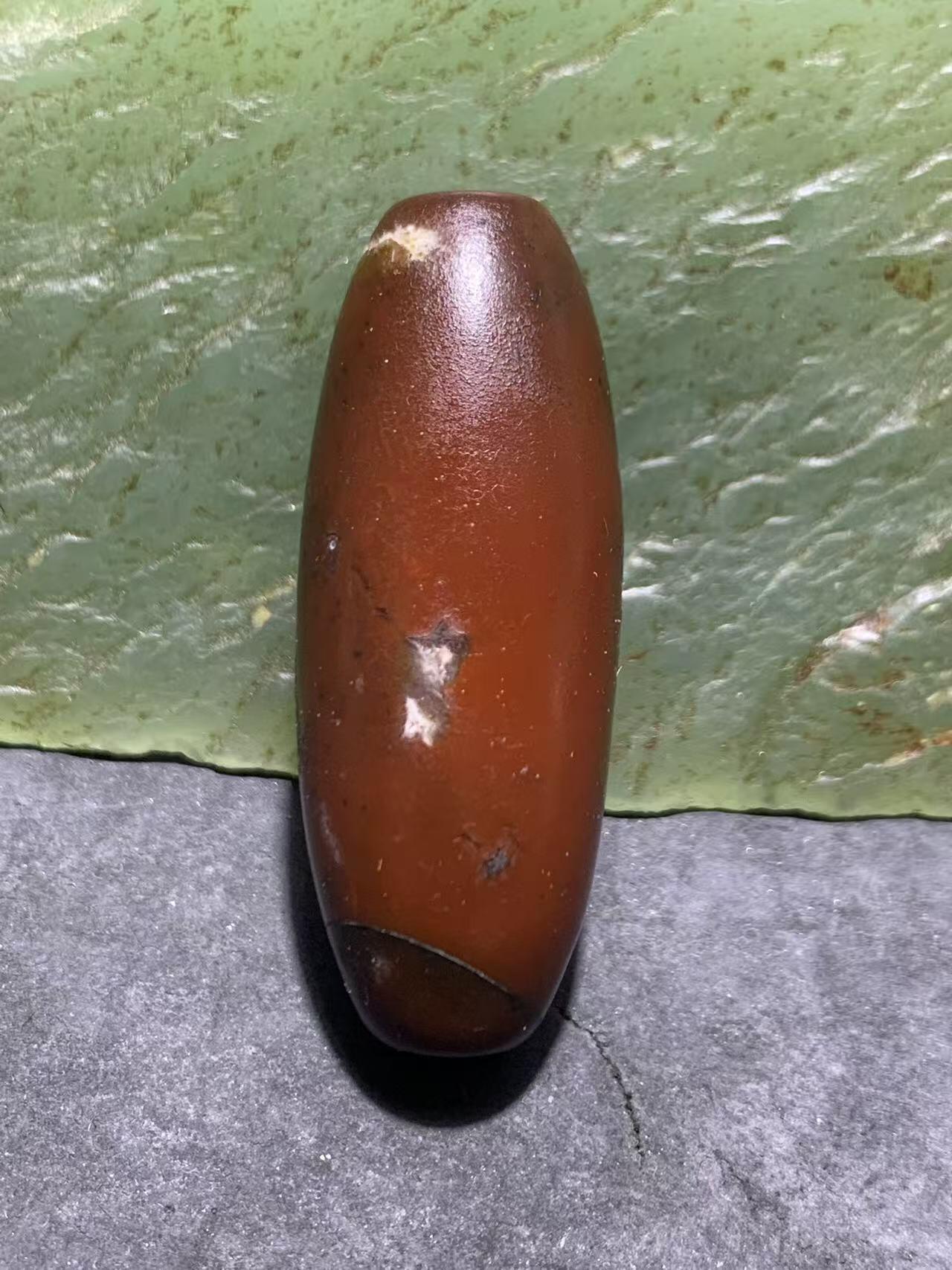 高玉化酒红色玛瑙随形桶珠一颗，