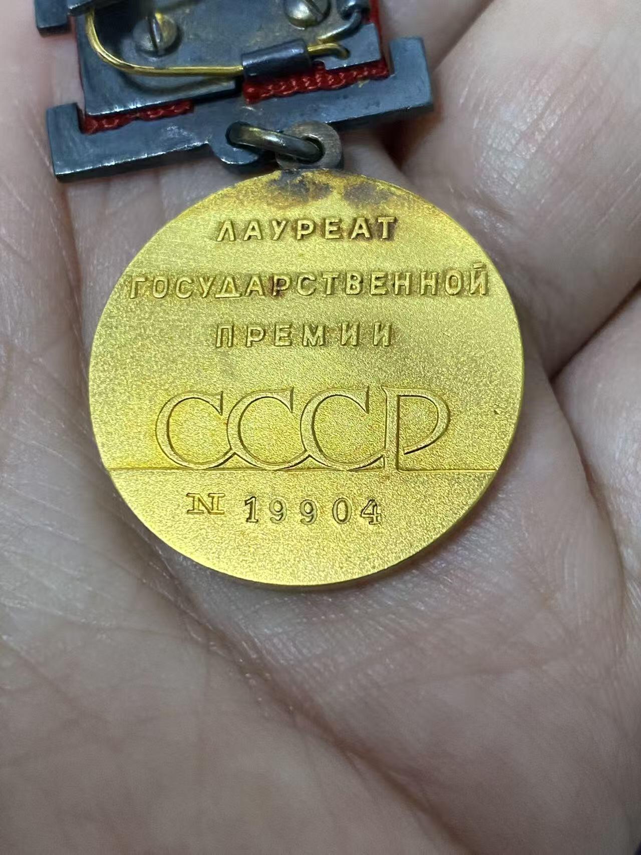 德国苏联勋章奖章年初拍卖 本次高价值物品较多 德因原因只上2-3图 具体的想要的请联系我要完整图。都经过讨论未标明则全部是原品，保真 放心拍。3月4日晚上九点结束在麦稀奇 找不到的加我qq或者微信都是184277308备注苏章拍卖。 苏联国家奖金 带原盒 证书 证书也带盒 非常好的大全套 14k 金 原环无开 部分氧化未清理也很漂亮 19904 属于最末期版本 87年颁发给里加糖果厂车间小组长 有部分报纸资料