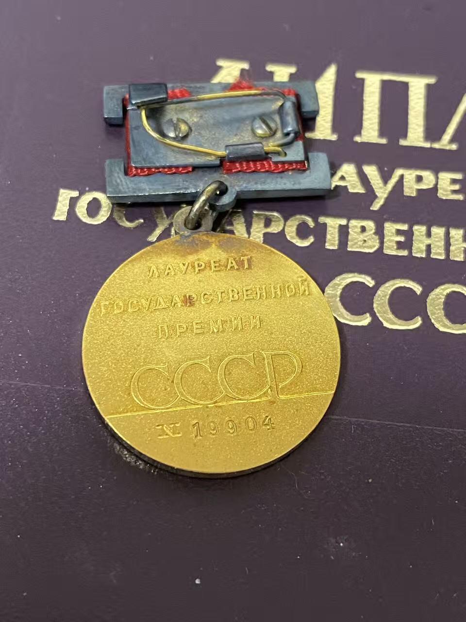 德国苏联勋章奖章年初拍卖 本次高价值物品较多 德因原因只上2-3图 具体的想要的请联系我要完整图。都经过讨论未标明则全部是原品，保真 放心拍。3月4日晚上九点结束在麦稀奇 找不到的加我qq或者微信都是184277308备注苏章拍卖。 苏联国家奖金 带原盒 证书 证书也带盒 非常好的大全套 14k 金 原环无开 部分氧化未清理也很漂亮 19904 属于最末期版本 87年颁发给里加糖果厂车间小组长 有部分报纸资料
