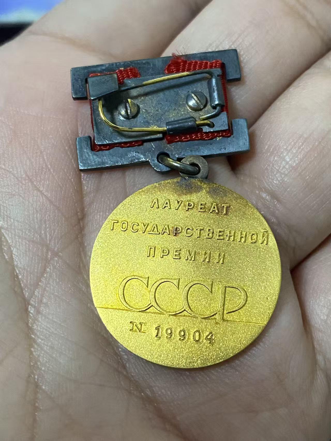 德国苏联勋章奖章年初拍卖 本次高价值物品较多 德因原因只上2-3图 具体的想要的请联系我要完整图。都经过讨论未标明则全部是原品，保真 放心拍。3月4日晚上九点结束在麦稀奇 找不到的加我qq或者微信都是184277308备注苏章拍卖。 苏联国家奖金 带原盒 证书 证书也带盒 非常好的大全套 14k 金 原环无开 部分氧化未清理也很漂亮 19904 属于最末期版本 87年颁发给里加糖果厂车间小组长 有部分报纸资料