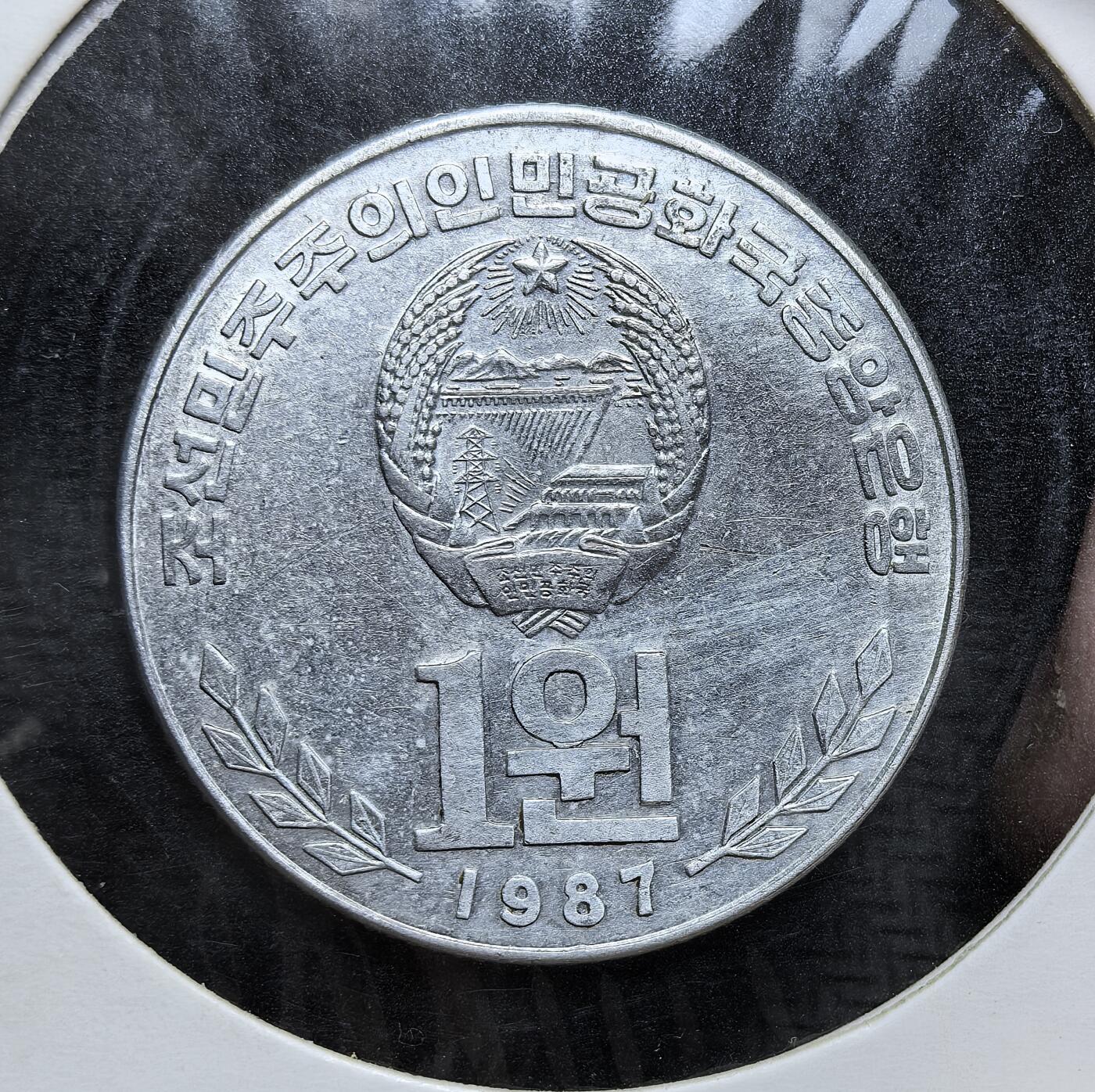 外国优质老铜币银币，正月十二晚九点倒数截拍，满百包邮可寄存，持续收拍 朝鲜人民大学壹元，正面为朝鲜国徽与面值，背面是人民大学习堂建筑及朝语铭文。此币是朝鲜重视国民教育、强化意识形态与国家文化建设的实物见证。