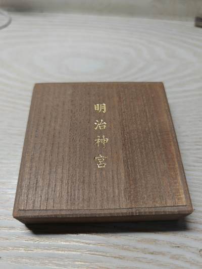 日本明治神宮的铜制纪念章 中央是双凤凰相对而立，周围环绕着菊花、牡丹等花卉纹样，顶部是日本皇室的十六瓣八重表菊纹。 背面是明治天皇的御制和歌，大意是：“在您的光辉下，朝阳格外耀眼；为了您，我心怀清爽而思念。 日本明治神宮的铜制纪念章 中央是双凤凰相对而立，周围环绕着菊花、牡丹等花卉纹样，顶部是日本皇室的十六瓣八重表菊纹。 背面是明治天皇的御制和歌，大意是：“在您的光辉下，朝阳格外耀眼；为了您，我心怀清爽而思念。