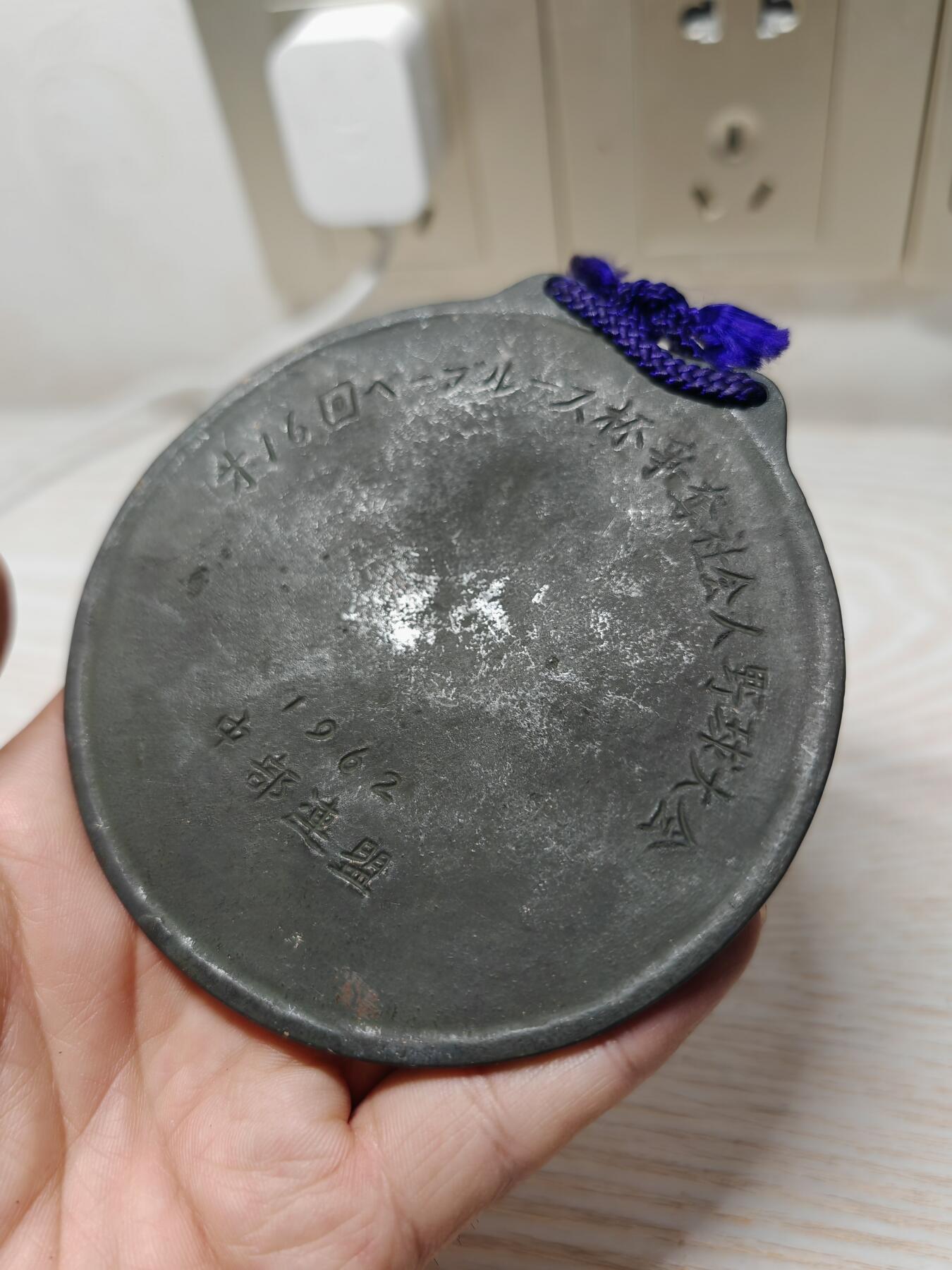 1962年日本第16届贝比·鲁斯杯争夺社会人棒球大会纪念奖牌 - 正面：浮雕为美国棒球传奇人物贝比·鲁斯（Babe Ruth）的头像，下方有他的英文签名“Babe Ruth”，两侧是棒球球棒的装饰图案 - 背面：刻有日文“第16回ベーブルース杯争奪社会人野球大会”，以及年份“1962”和所属联盟“中部連盟”。