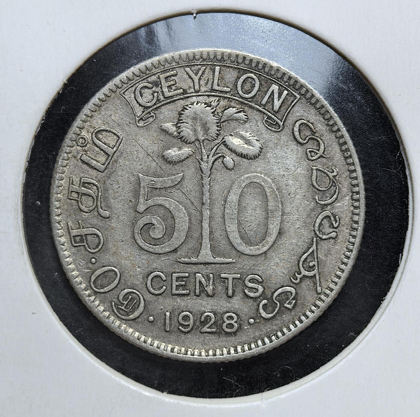 外国优质老铜币银币，正月十二晚九点倒数截拍，满百包邮可寄存，持续收拍 英属锡兰1928年50分银币，正面为英王乔治五世像，背面是锡兰国树铁木树与双语面值。发行于一战后经济恢复期，是英国殖民统治的货币遗存，见证了锡兰的殖民贸易与多元文化融合。
