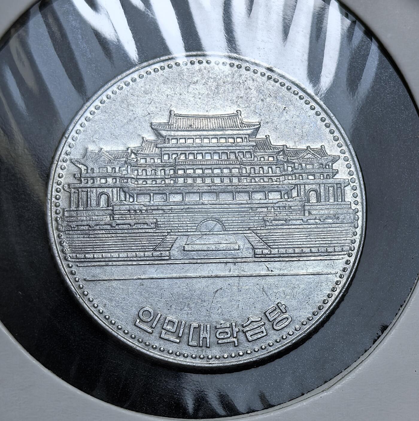 外国优质老铜币银币，正月十二晚九点倒数截拍，满百包邮可寄存，持续收拍 朝鲜人民大学壹元，正面为朝鲜国徽与面值，背面是人民大学习堂建筑及朝语铭文。此币是朝鲜重视国民教育、强化意识形态与国家文化建设的实物见证。