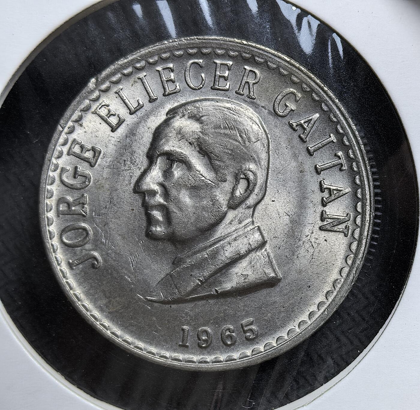 外国优质老铜币银币，正月十二晚九点倒数截拍，满百包邮可寄存，持续收拍 哥伦比亚1965年50分铜镍纪念币直径30.4mm，正面为遇刺的左翼领袖豪尔赫・盖坦头像，背面是哥伦比亚国徽。发行于盖坦遇刺 20 周年，是哥伦比亚反思暴力政治、重塑国家记忆的重要实物见证。