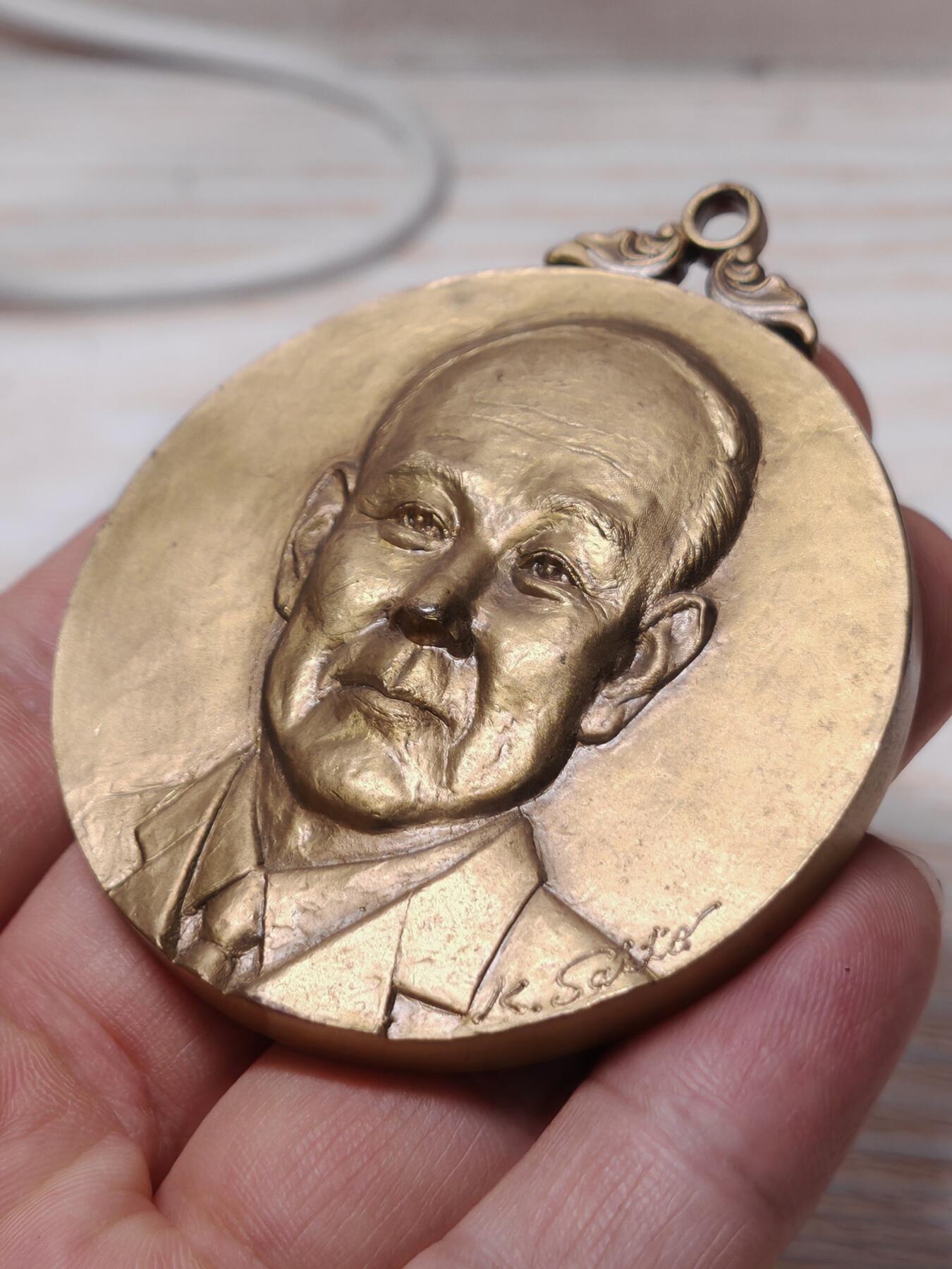 2002年第24届克罗斯塔宁国际大会纪念奖牌人物立体 - 正面：浮雕为日健総本社的创始人田中美穂的头像，右下角有雕刻师签名。 - 背面：刻有“第24回クロスタニン国際大会”、“株式会社 日健総本社”和年份“2002”，并配有飞马与人物的神话风格浮雕。 浮雕工艺精细，背面的飞马神话图案设计独特，具有一定的艺术观赏性。