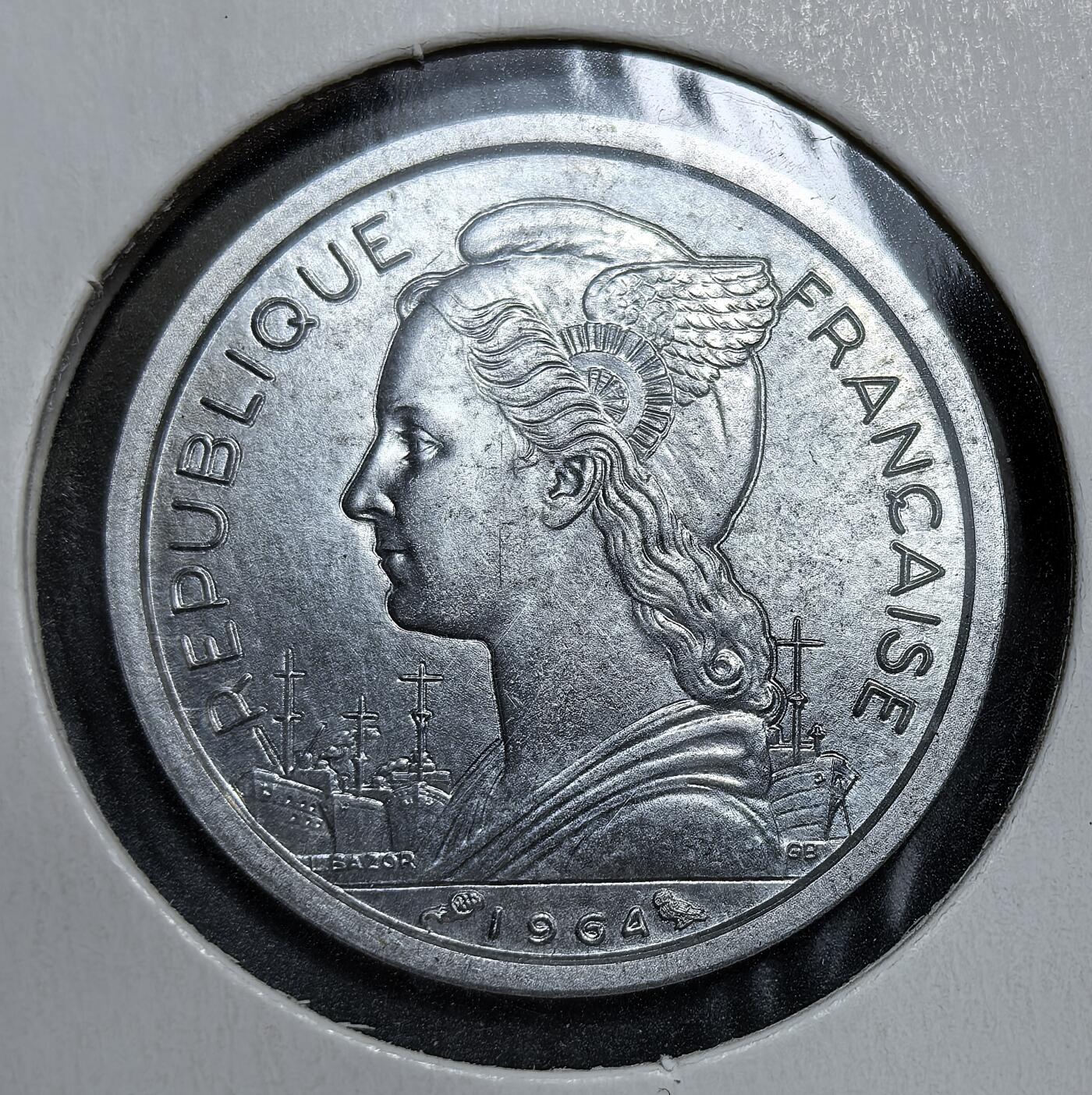 外国优质老铜币银币，正月十二晚九点倒数截拍，满百包邮可寄存，持续收拍 法属留尼汪1964年1法郎，正面为带翼自由女神与法国战舰，背面是象征留尼汪经济支柱的甘蔗林。发行于留尼汪作为法国海外省的稳定期，是法国殖民体系下海外领地货币体系的实物见证。