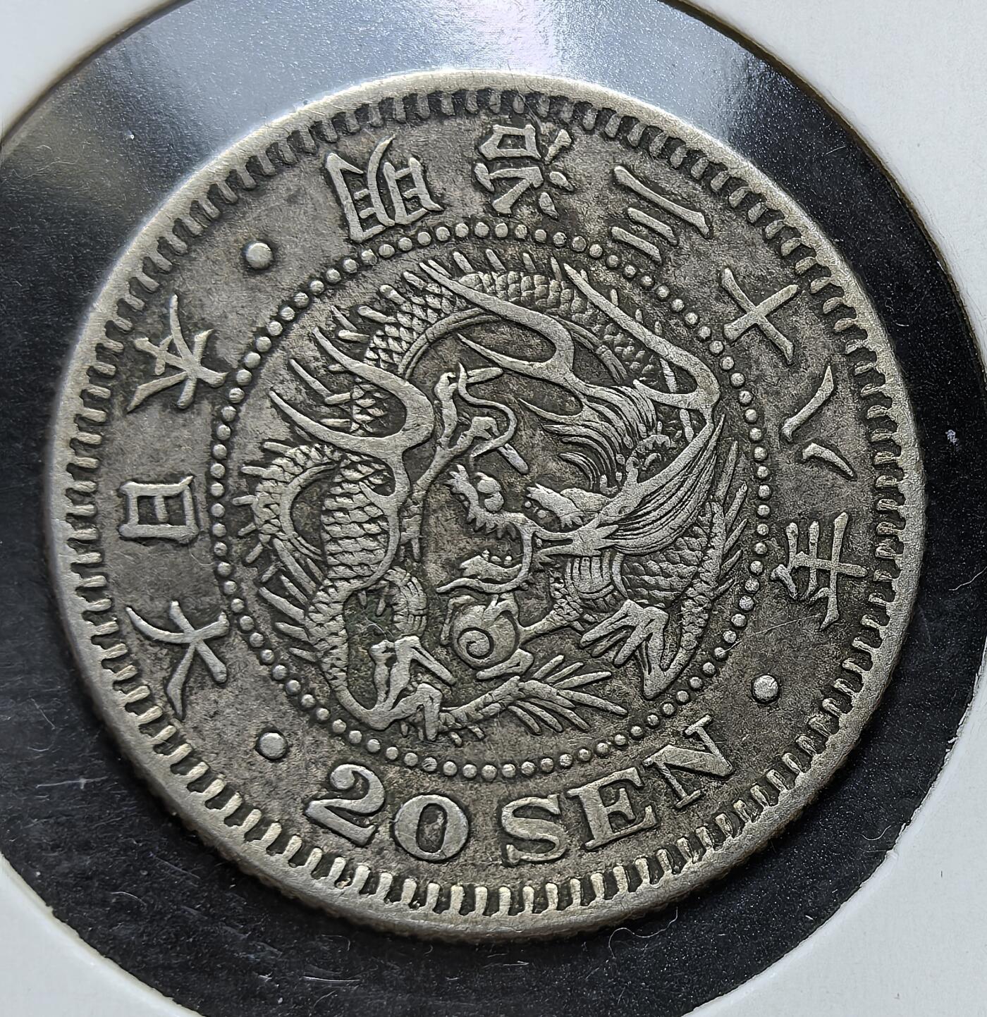 外国优质老铜币银币，正月十二晚九点倒数截拍，满百包邮可寄存，持续收拍 日本明治三十八年（1905 年）二十钱银币，发行于日俄战争后。币面以龙纹彰显国威，搭配菊花纹章与 “二十钱” 字样，是日本近代化与对外扩张时期的重要流通货币，见证了其东亚霸权崛起的历史节点。