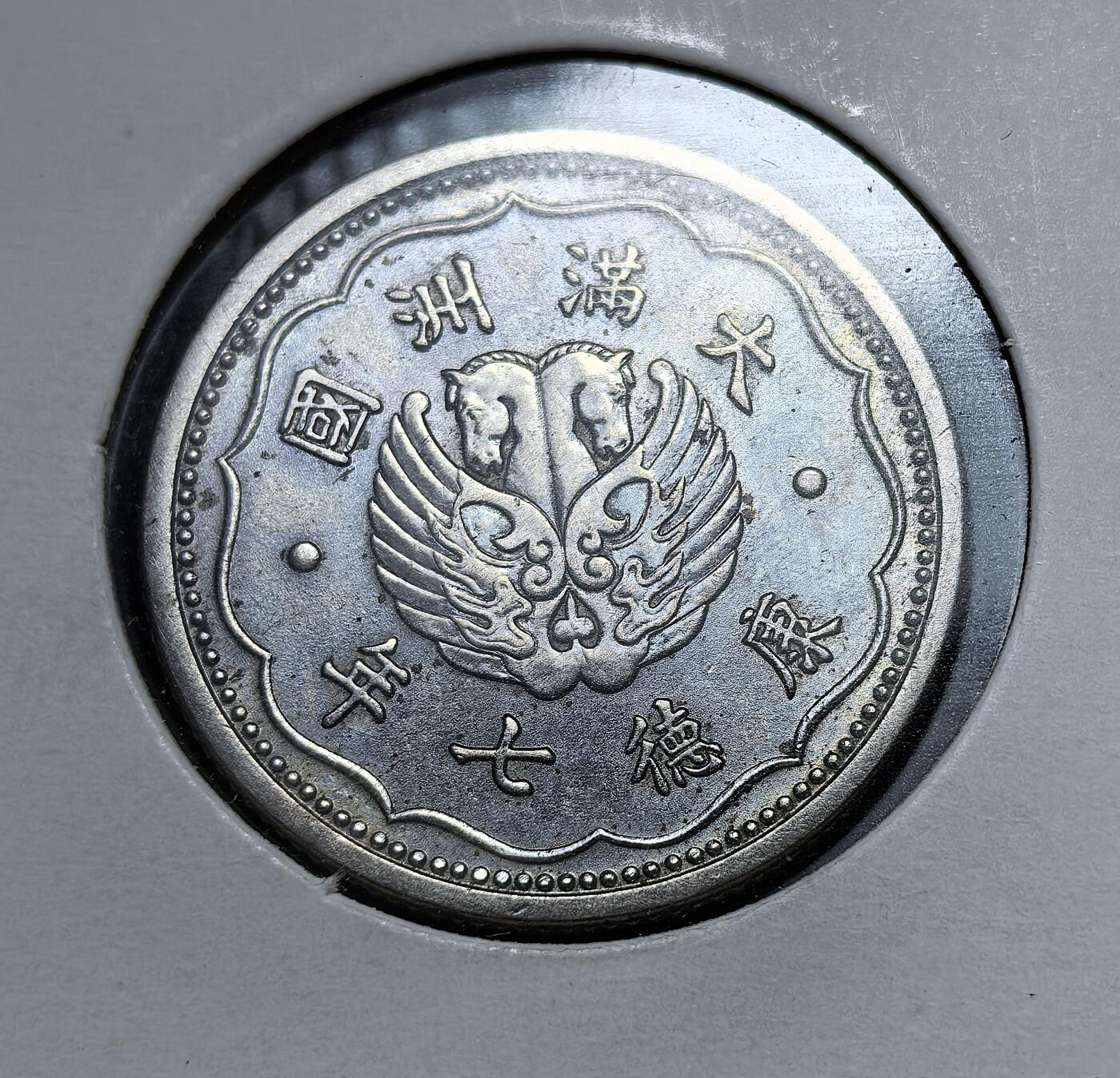 外国优质老铜币银币，正月十二晚九点倒数截拍，满百包邮可寄存，持续收拍 伪满洲国康德七年（1940 年）壹角镍币，正面为 “双头马翼龙” 图案与 “大满洲国” 字样，背面是 “壹角” 面值与云纹。它是日本扶植傀儡政权、推行殖民经济统治的重要货币遗存，见证了东北沦陷的屈辱历史。