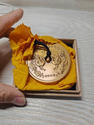 日本明治神宮的铜制纪念章 中央是双凤凰相对而立，周围环绕着菊花、牡丹等花卉纹样，顶部是日本皇室的十六瓣八重表菊纹。 背面是明治天皇的御制和歌，大意是：“在您的光辉下，朝阳格外耀眼；为了您，我心怀清爽而思念。 日本明治神宮的铜制纪念章 中央是双凤凰相对而立，周围环绕着菊花、牡丹等花卉纹样，顶部是日本皇室的十六瓣八重表菊纹。 背面是明治天皇的御制和歌，大意是：“在您的光辉下，朝阳格外耀眼；为了您，我心怀清爽而思念。