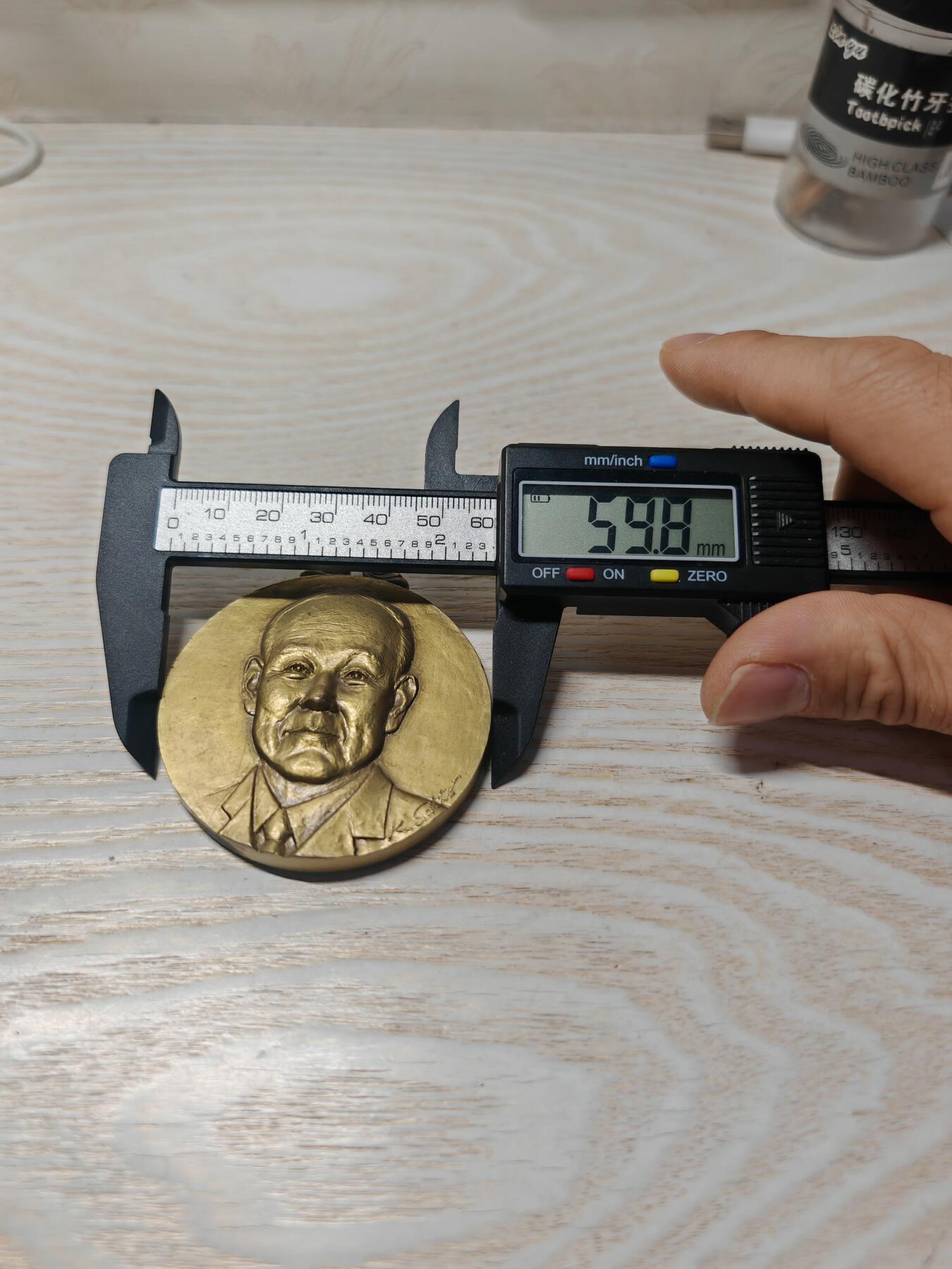 2002年第24届克罗斯塔宁国际大会纪念奖牌人物立体 - 正面：浮雕为日健総本社的创始人田中美穂的头像，右下角有雕刻师签名。 - 背面：刻有“第24回クロスタニン国際大会”、“株式会社 日健総本社”和年份“2002”，并配有飞马与人物的神话风格浮雕。 浮雕工艺精细，背面的飞马神话图案设计独特，具有一定的艺术观赏性。