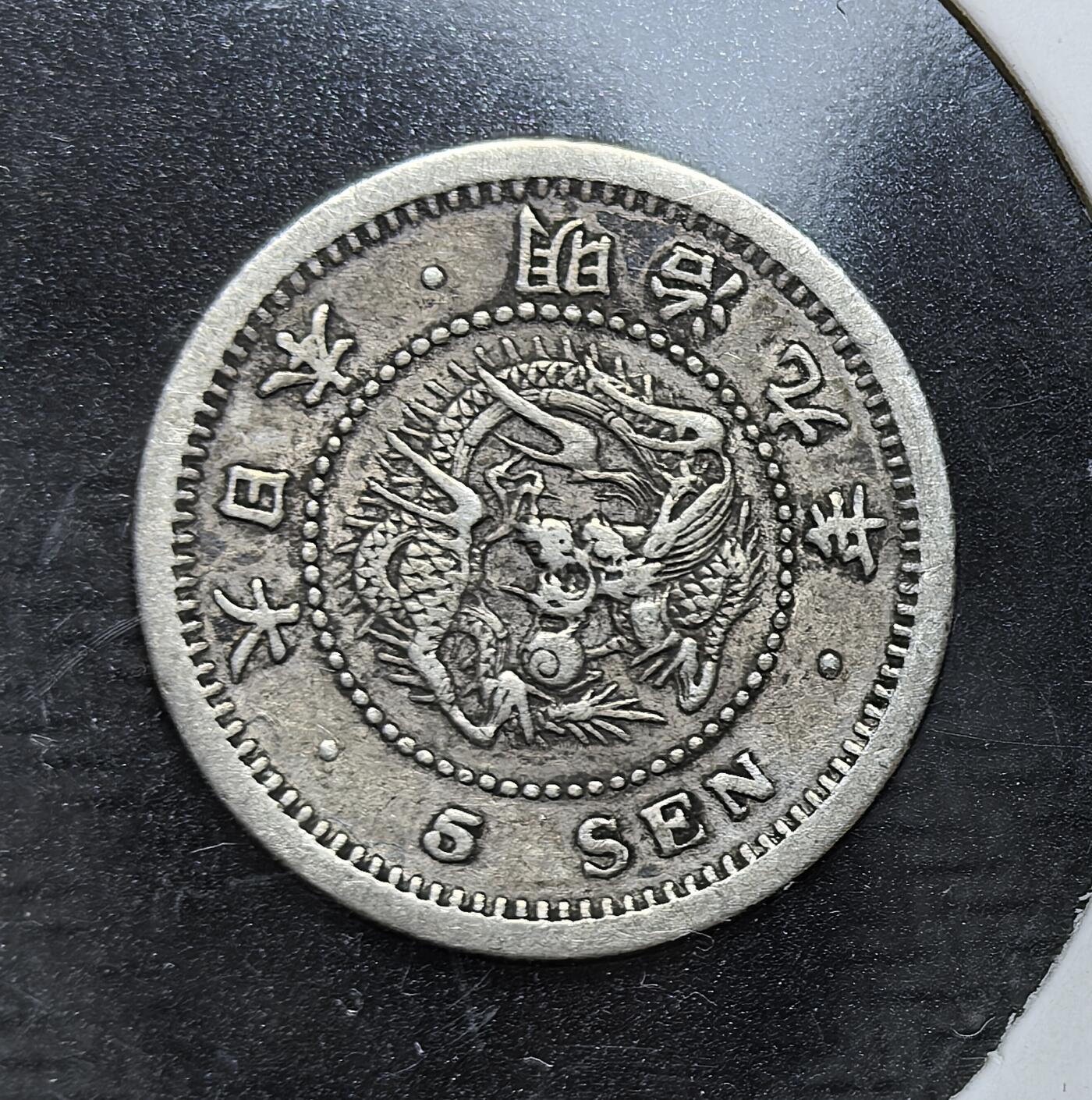 外国优质老铜币银币，正月十二晚九点倒数截拍，满百包邮可寄存，持续收拍 日本明治九年（1876 年）五钱银币，属明治维新初期货币。币面以龙纹彰显皇权，搭配菊花纹章与 “五钱” 字样，是日本货币近代化的早期实物，见证了其经济转型与币制统一进程。