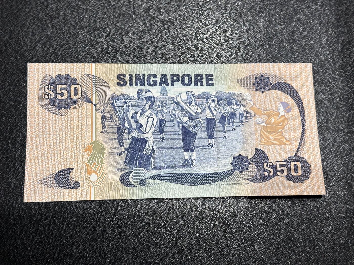《外钞收藏家》第六百一十三期（ 精品场）（长期征集拍品、欢迎藏友们联系合作） 新加坡鸟版50元（音乐题材纸币，全程无47豹子号999）	UNC 但有潮斑