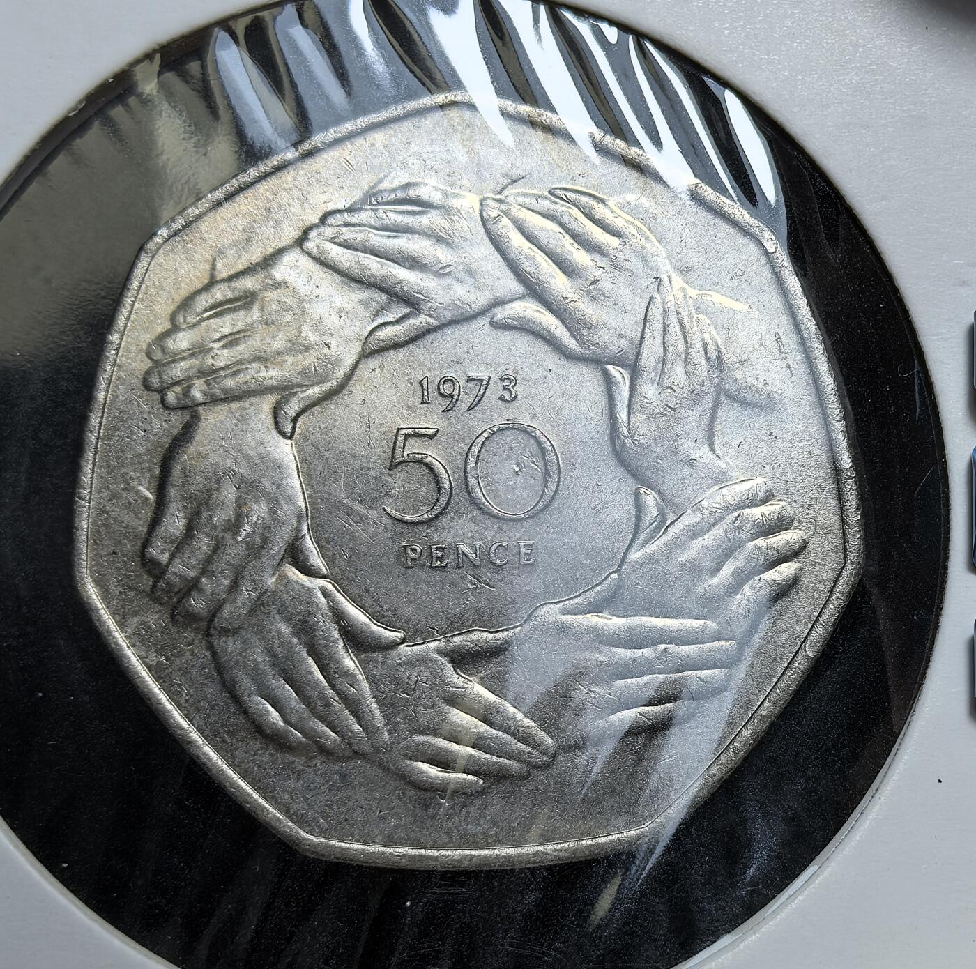外国优质老铜币银币，正月十二晚九点倒数截拍，满百包邮可寄存，持续收拍 英国1973年加入欧共体50便士纪念币直径30mm。正面为伊丽莎白二世头像，背面是九只手相握的图案，象征欧洲团结。它是英国融入欧洲一体化进程的重要实物见证，也预示了半个世纪后脱欧的历史转折。