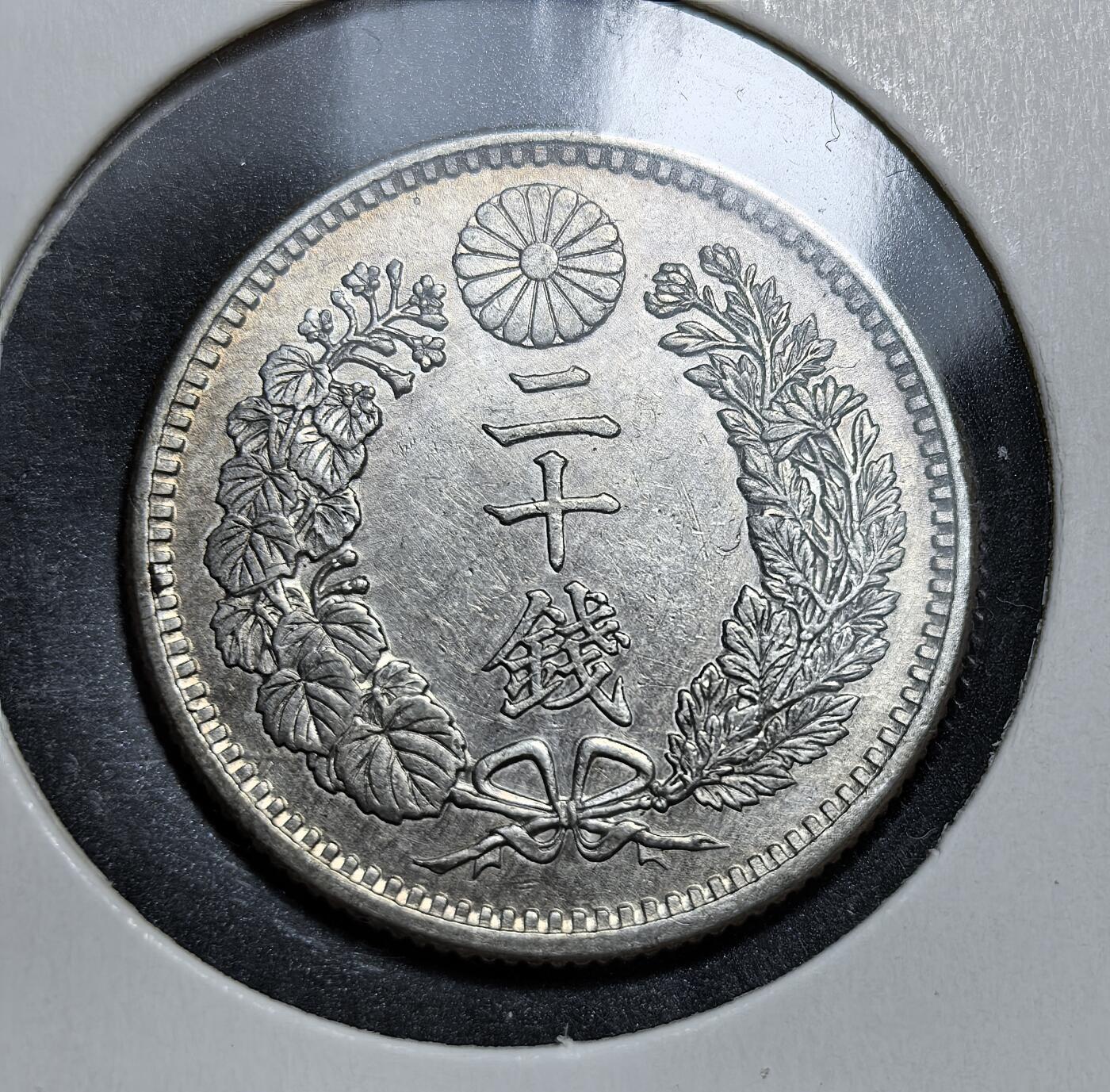 外国优质老铜币银币，正月十二晚九点倒数截拍，满百包邮可寄存，持续收拍 极美品日本明治三十二年（1899 年）二十钱银币，正面为龙纹，背面是菊花纹章与 “二十钱” 字样。它是明治维新后日本近代化货币体系的产物，见证了日本崛起为东亚强国的历史进程。