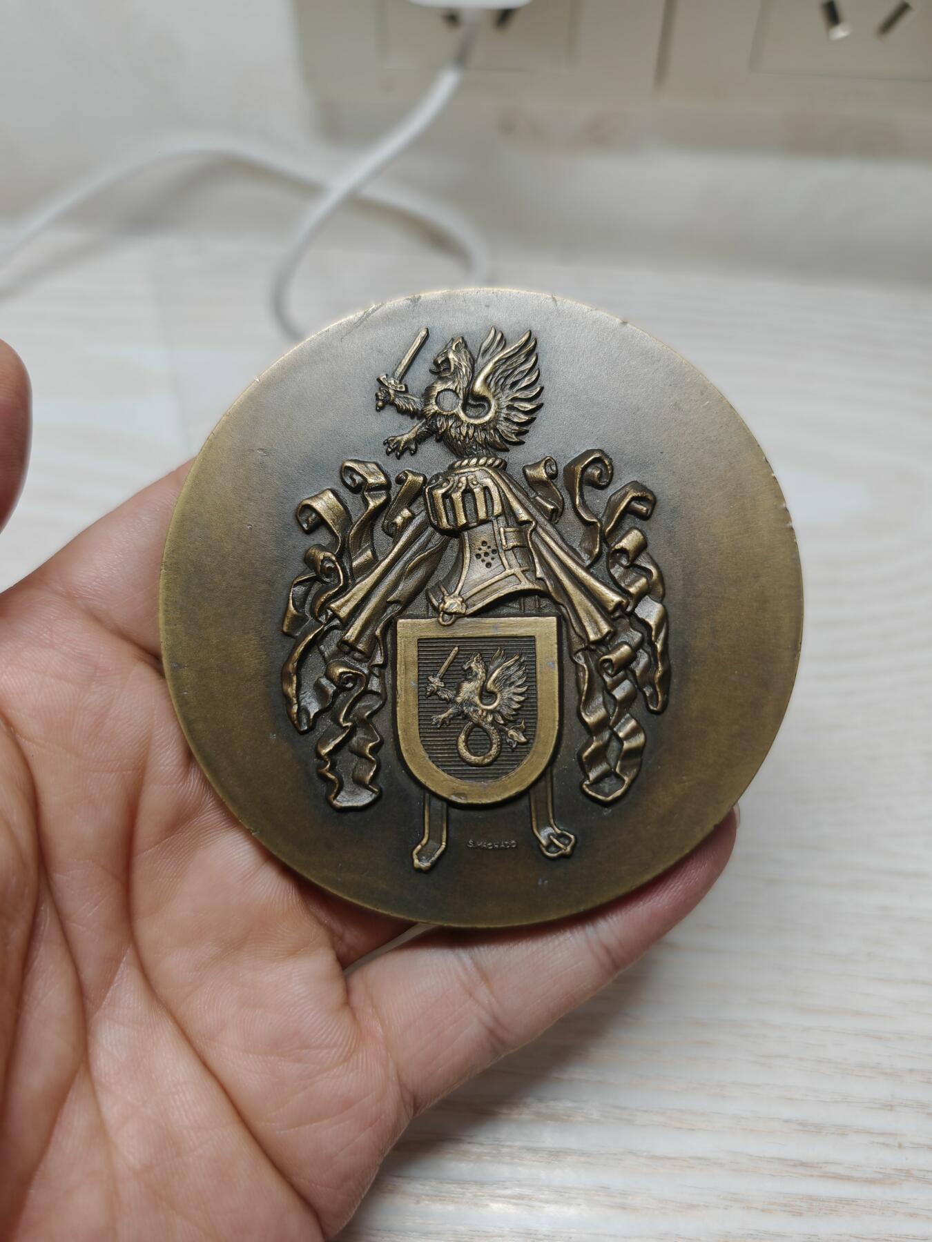 葡萄牙少见军事题材纪念铜章 - 主图案：葡萄牙传统的持剑双头鹰盾徽，这是葡萄牙军事机构的经典象征，代表着指挥权与历史传承。 - 工艺特征：采用高浮雕工艺，整个设计体现了陆、海、空三军的统一指挥与协调，是葡萄牙军事体系的核心象征。