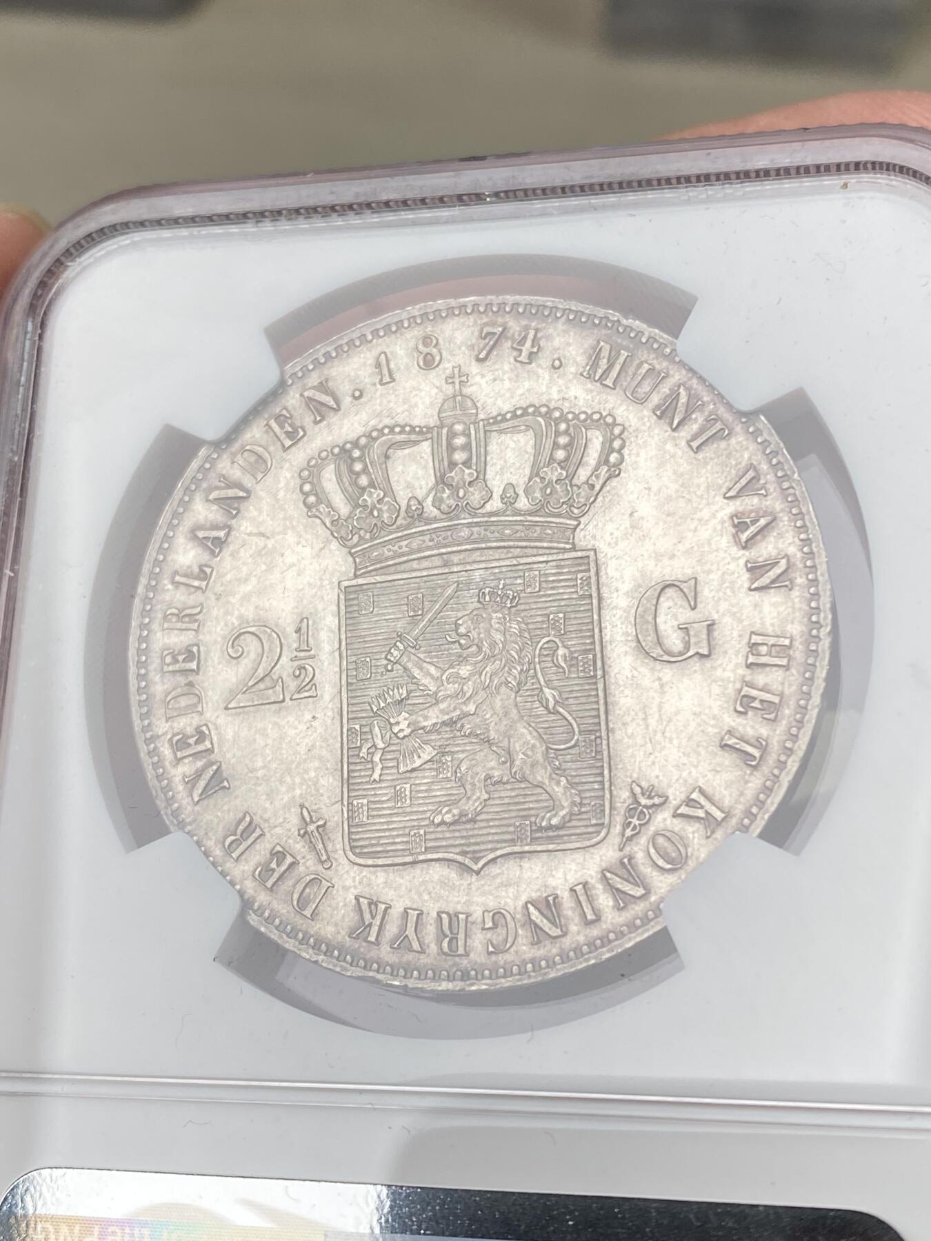 万国钱币拍卖第062期 NGC MS62 1874年荷兰王国威廉三世2.5盾大银币 原味欧陆淡彩环绕 浮雕效果极美实物状态非常赞