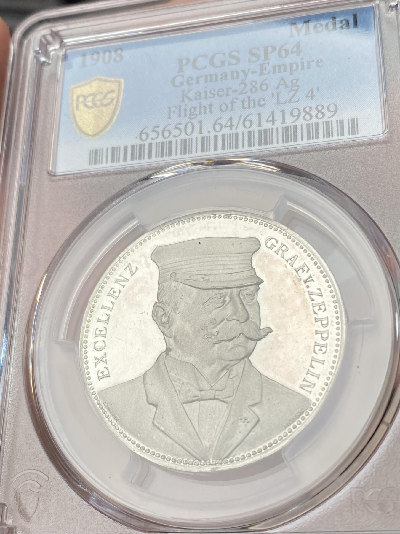 万国钱币拍卖第062期 PCGS SP64 1924年德国齐柏林伯爵齐柏林飞艇飞越斯特拉斯堡纪念银章 齐柏林飞艇银章很多 带帽正面像配斯特拉斯堡景观罕见 通体超深度精制镜面喷砂顶级工艺