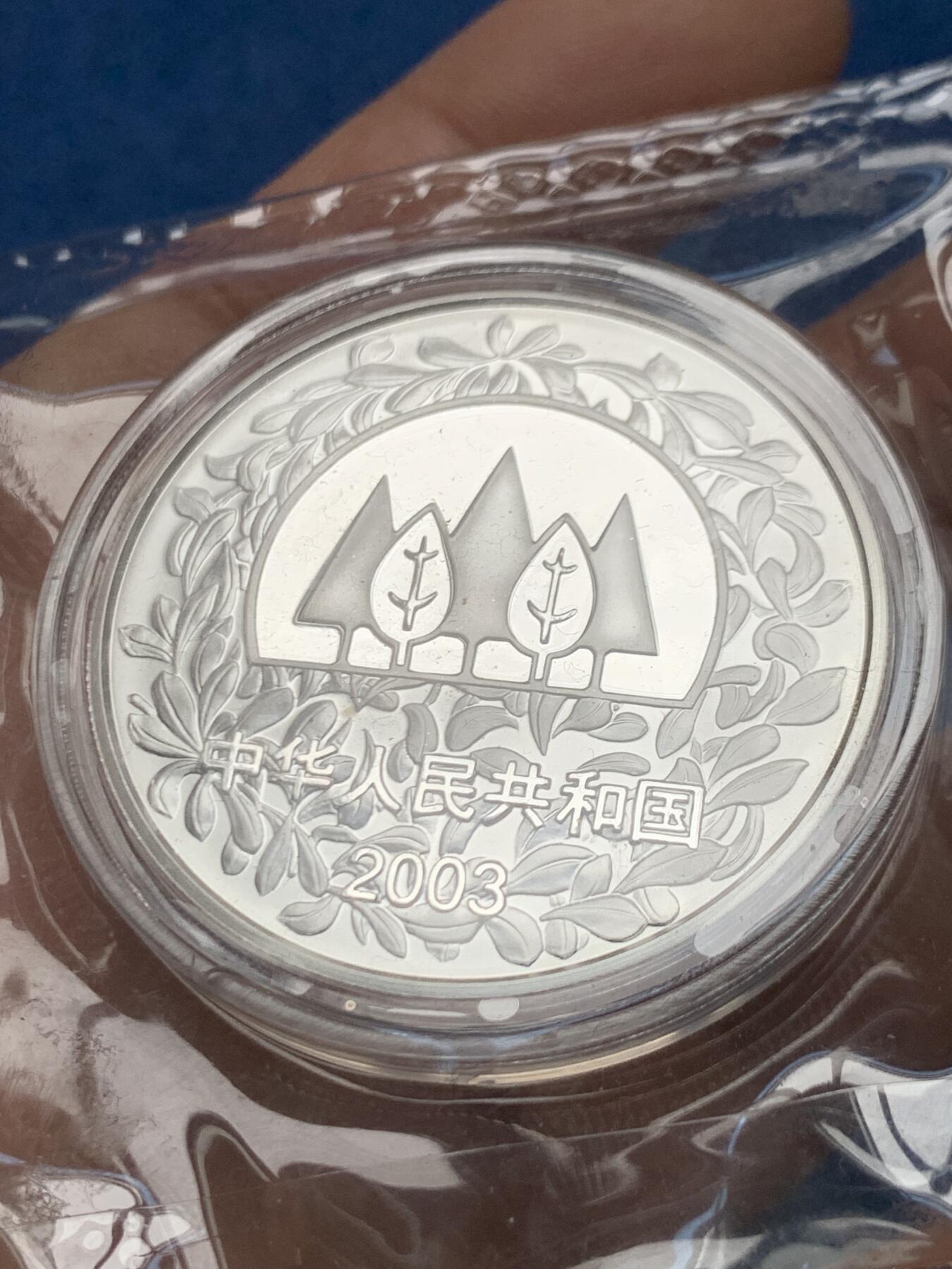 《竞宝斋》第466场 周日，周一 2场连拍 （全场包邮）欢迎送拍 中国2003年林海飞鸟银币 环保植树主题 发行量3万 999银 1盎司 31.1克。原封装好品，无氧化无白斑。