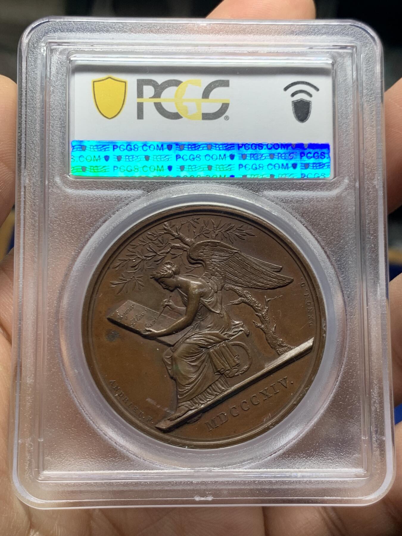 《竞宝斋》第466场 周日，周一 2场连拍 （全场包邮）欢迎送拍 PCGS SP64 亚军分 法国1814年沙皇亚历山大一世访问巴黎铜章 正面沙皇月桂冠高浮雕，完全拿章典型风格头像，背面天使坐于树荫下书写历史，纪念沙皇占领期访巴黎造币厂，第六次反法同盟胜利，法兰西第一帝国覆灭，拿皇退位流放，巴黎由俄军掌管。作为胜利者的沙皇骑着白马率大军通过凯旋门，不知他是否满脑一年前拿皇攻占莫斯科场景，与其说“访问巴黎”，不如说彰显复仇拿皇的耀武扬威。加厚盒