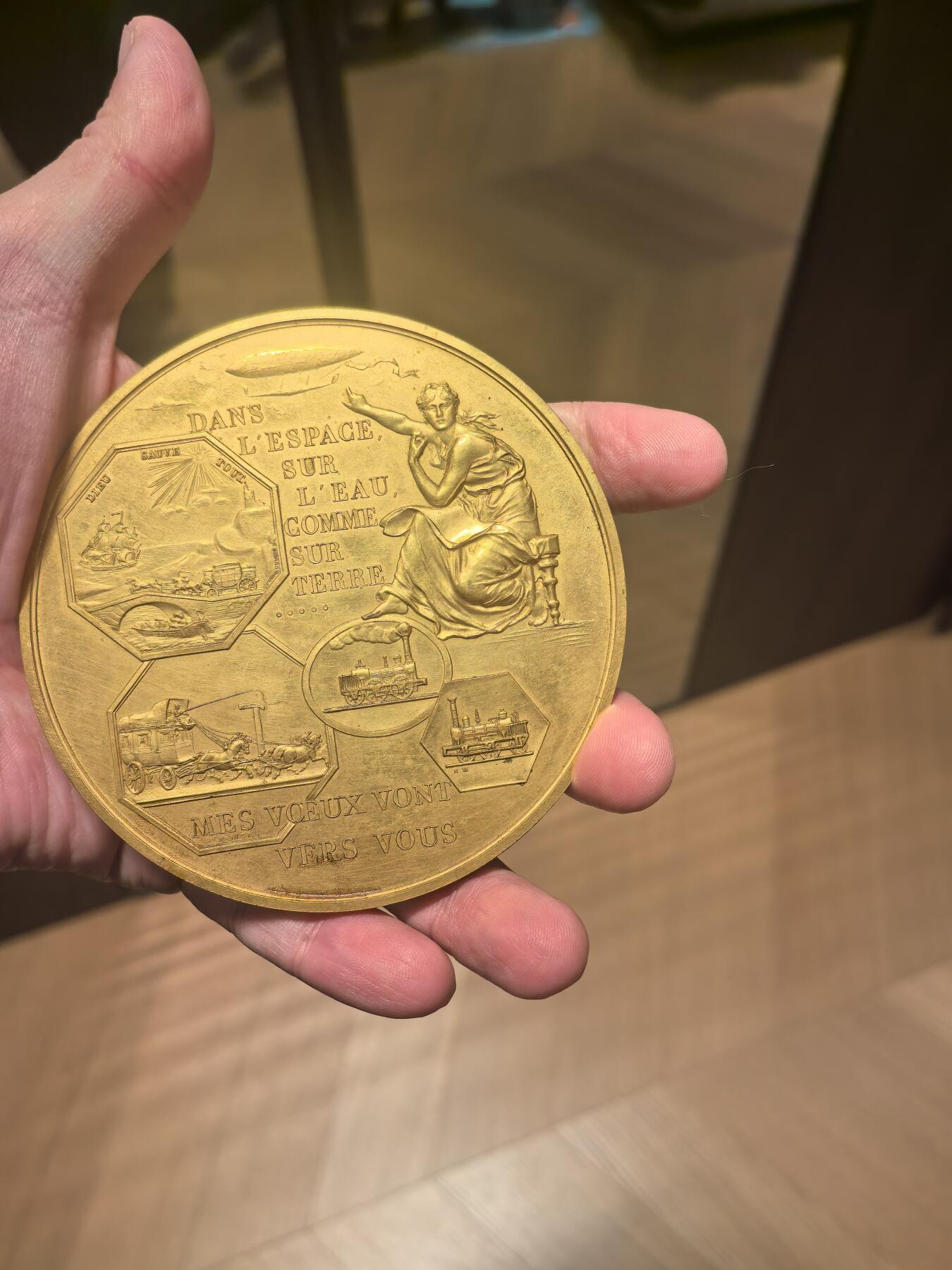 欧洲铜章和回流杂项第一场 铜章深度解析：巴黎造币厂叠币章（海陆空交通主题） 这枚铜章是法国新艺术运动时期的经典作品，由巴黎造币厂（Monnaie de Paris）发行，以其独特的“叠币”设计和对人类交通发展的描绘而闻名