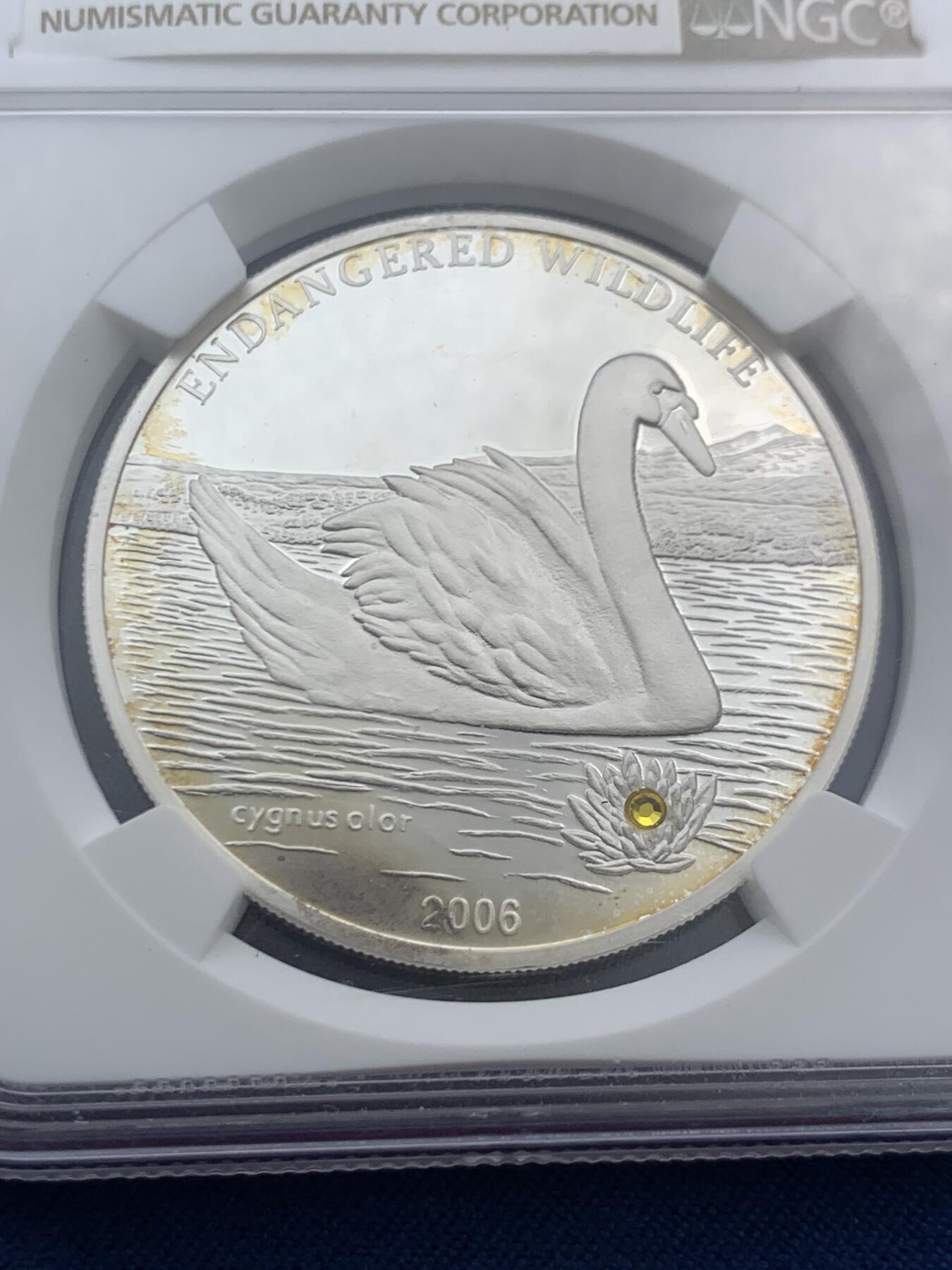 《竞宝斋》第466场 周日，周一 2场连拍 （全场包邮）欢迎送拍 NGC PF69UC 2006年蒙古濒危野生动物系列—天鹅，“镶嵌黄水晶”镜面高浮雕精制银币，500图格里克，925银，25克，冠军分，2500枚发行量，细节见图。