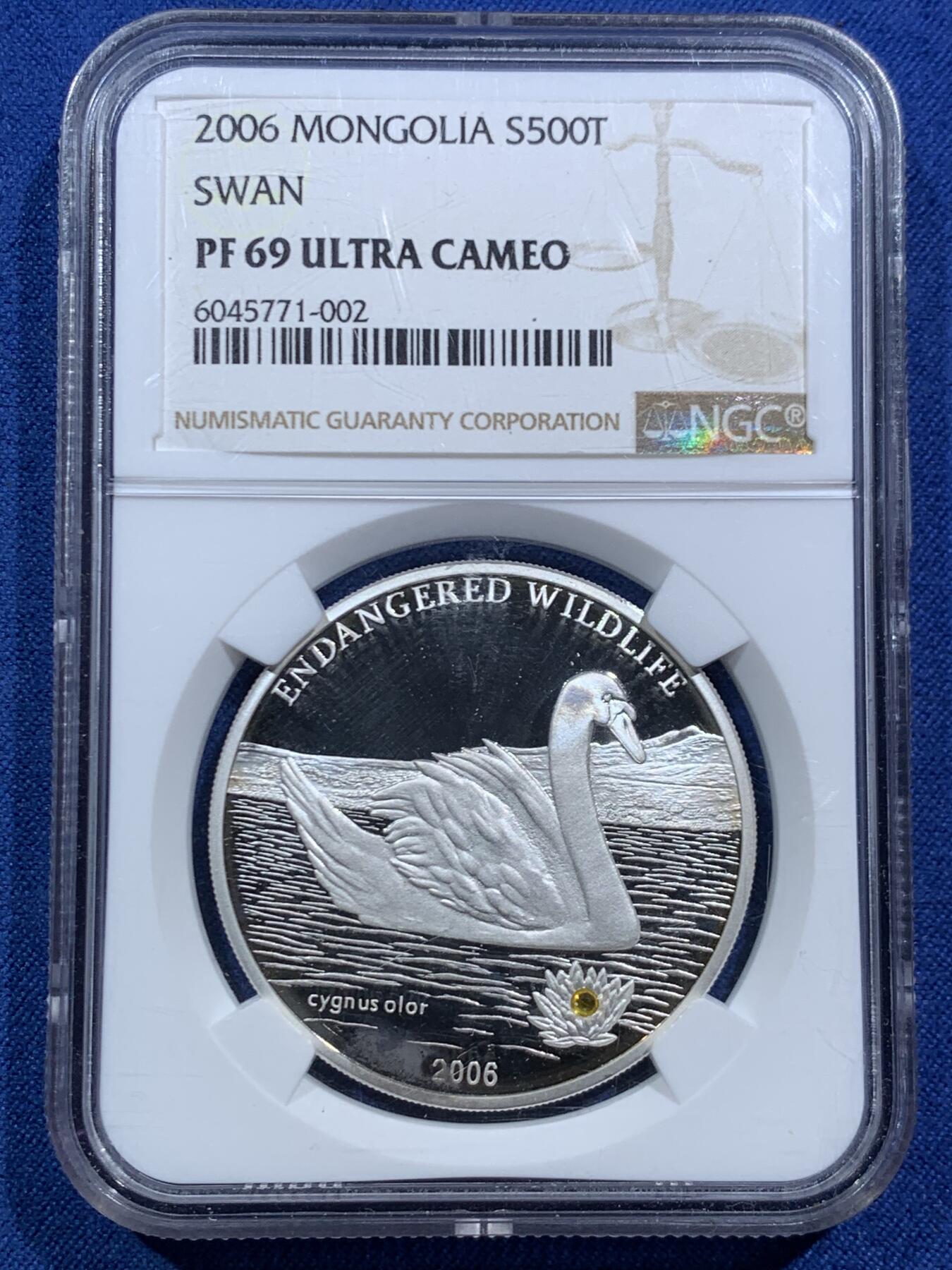 《竞宝斋》第466场 周日，周一 2场连拍 （全场包邮）欢迎送拍 NGC PF69UC 2006年蒙古濒危野生动物系列—天鹅，“镶嵌黄水晶”镜面高浮雕精制银币，500图格里克，925银，25克，冠军分，2500枚发行量，细节见图。
